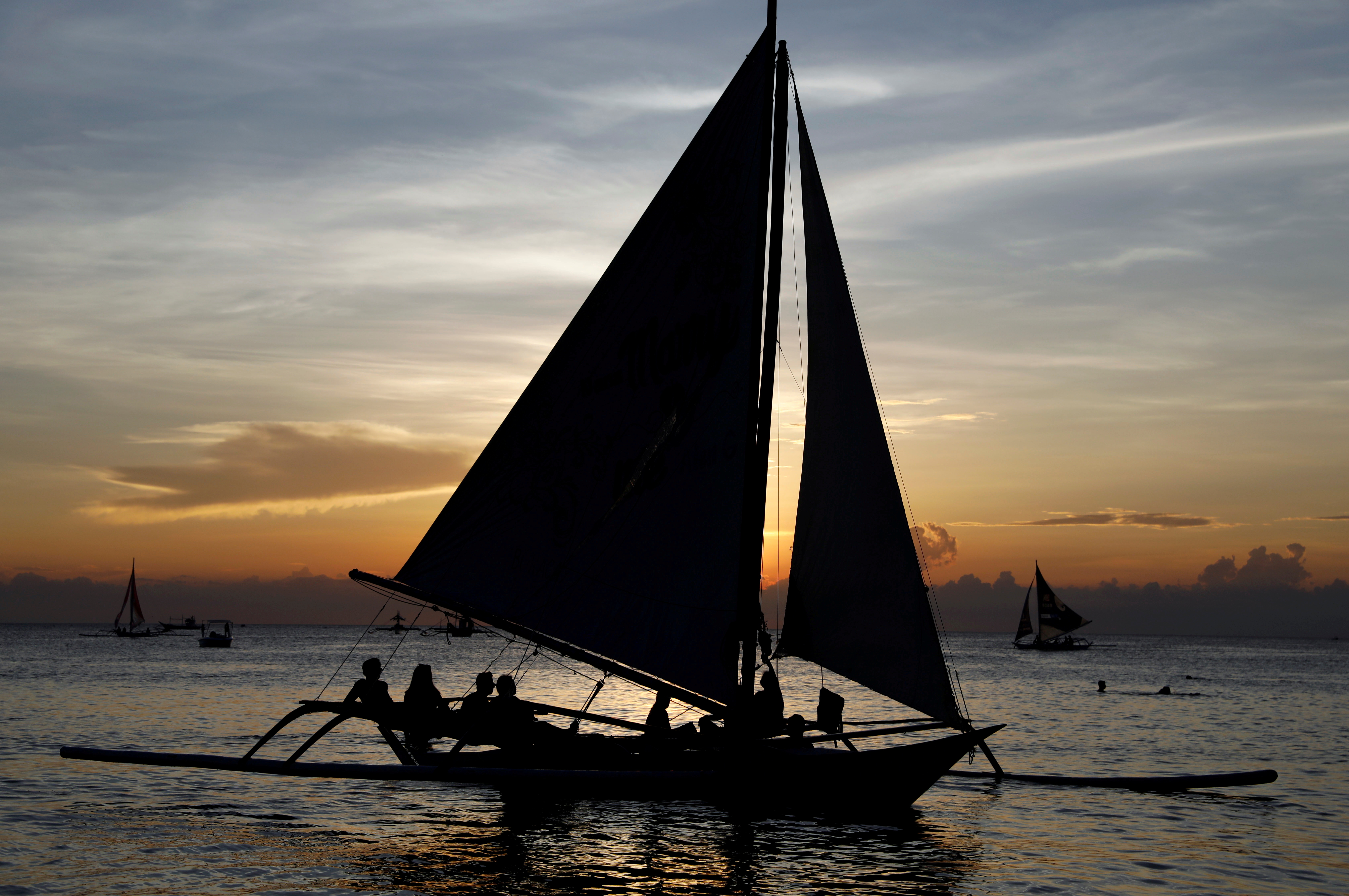 Tourists watch sunset aboard sailboats, one day before the temporary closure of the holiday island Boracay, in the Philippines