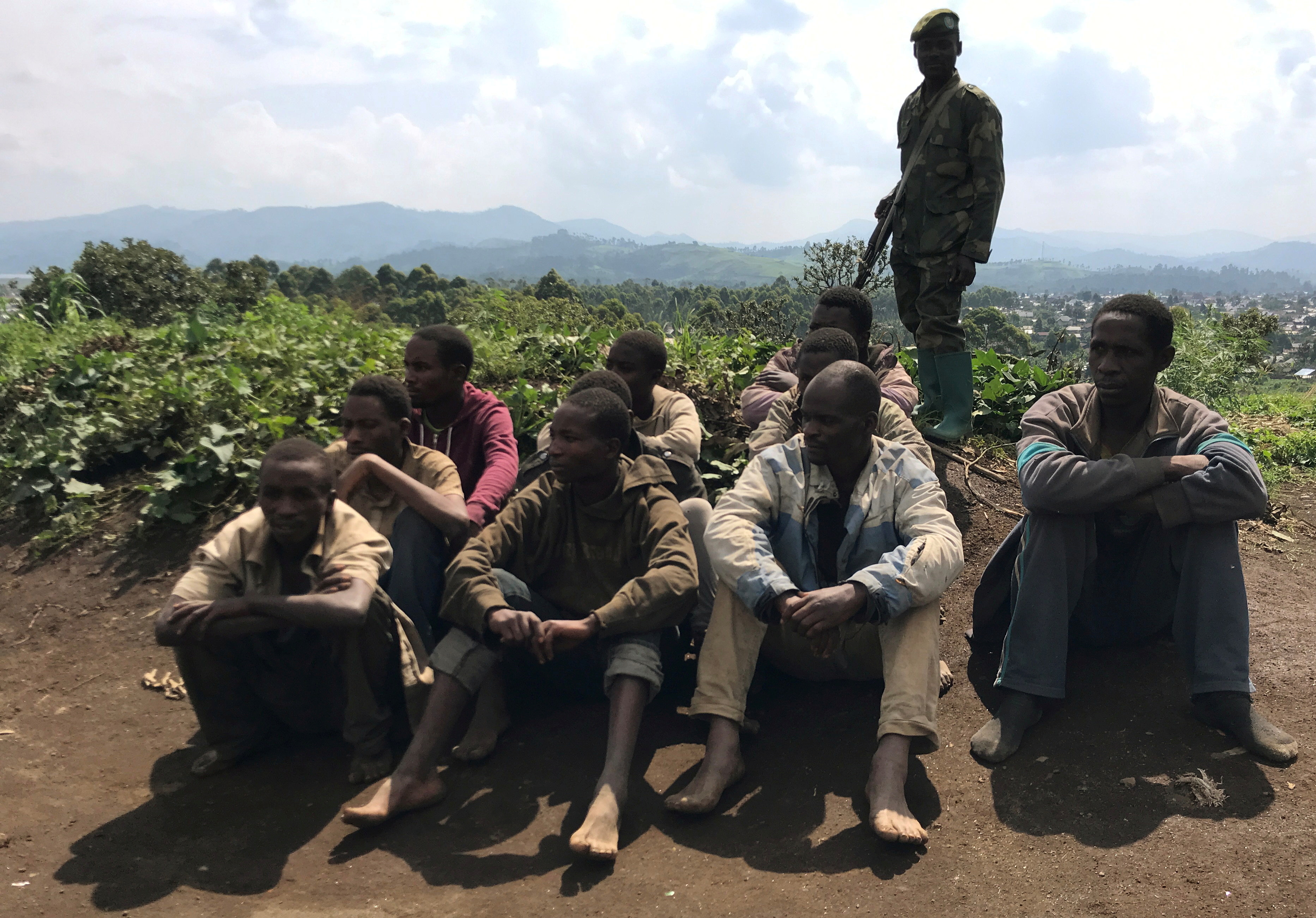 Congolese Mai-Mai rebels who surrendered their weapons to government officials sit guarded in Kitchanga, in the Masisi territory of North Kivu province, in the Democratic Republic of Congo June 21, 2021. Picture taken June 21, 2021. REUTERS/Djaaffar Al Katanty