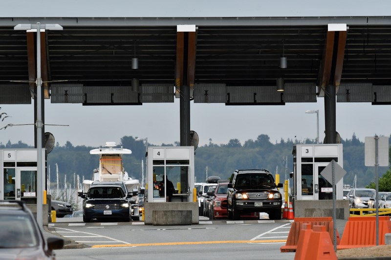 Travellers line up to enter Canada after border restrictions were loosened to allow fully vaccinated U.S. residents, after the coronavirus disease (COVID-19) pandemic forced an unprecedented 16-month ban that many businesses complained was crippling them, at the Peace Arch border crossing in Surrey, British Columbia, Canada August 9, 2021. REUTERS/Jennifer Gauthier