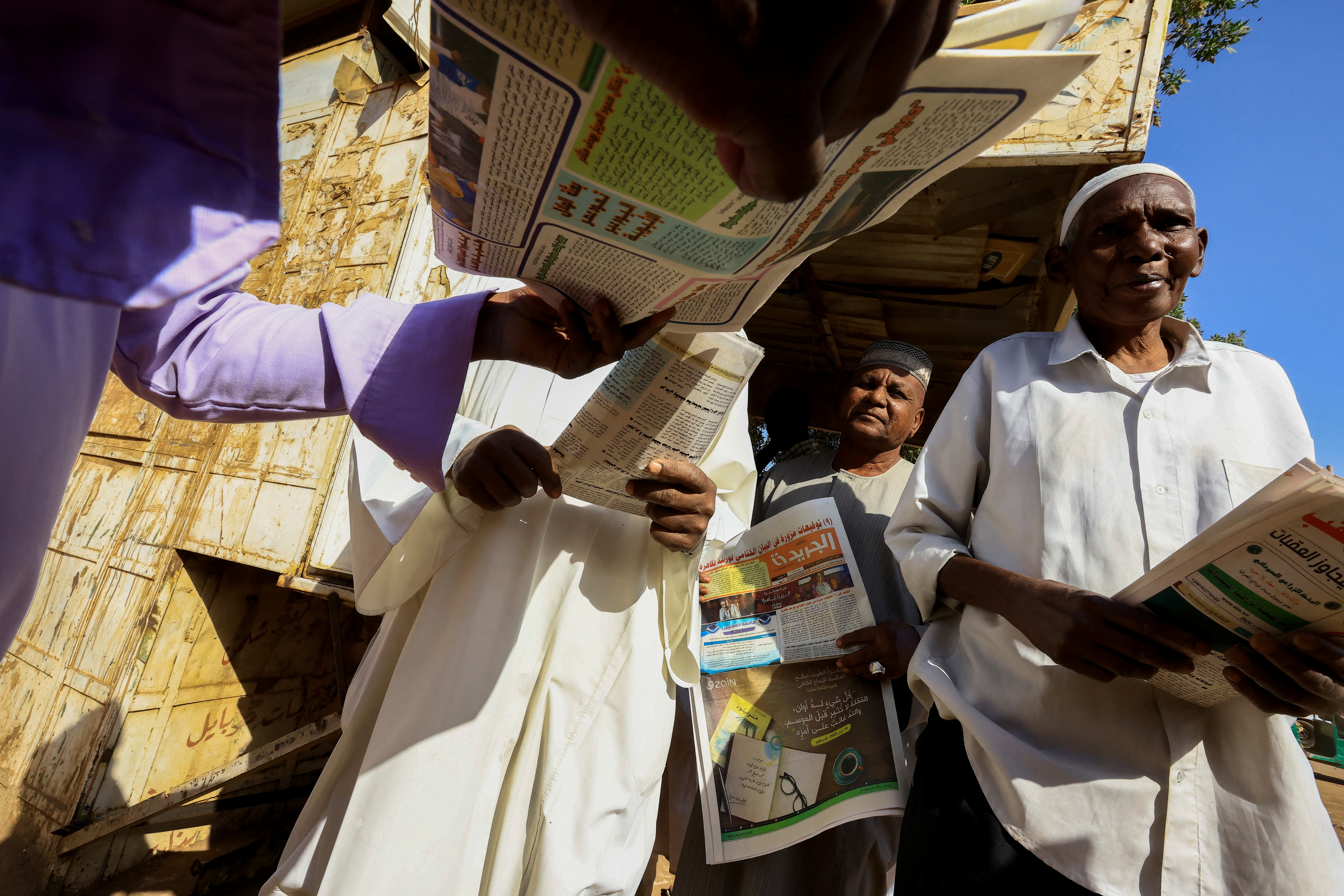 People gather to read and get newspapers at the Al-Zikriyat library in Omdurman