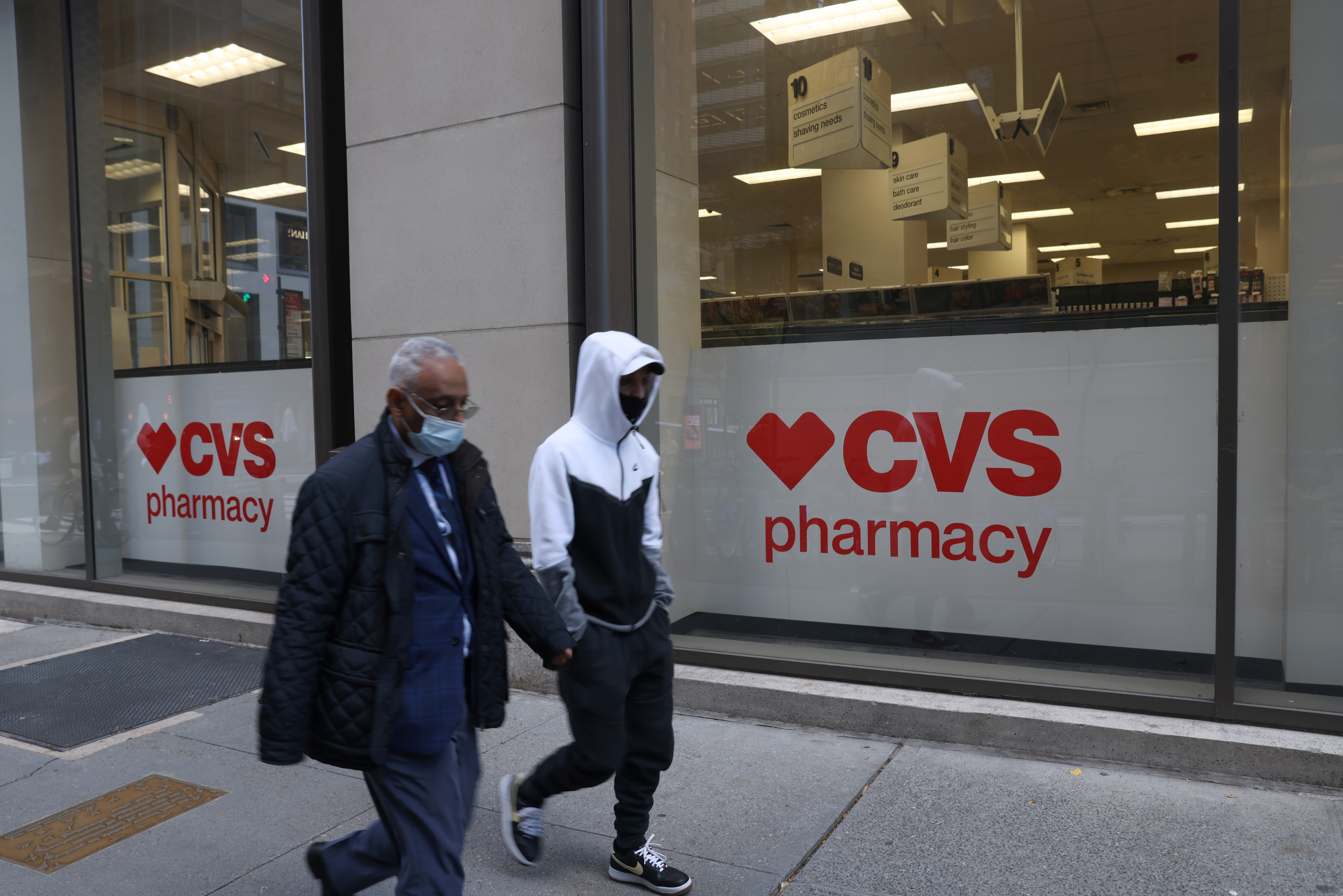 People walk by a CVS pharmacy store in Manhattan, New York