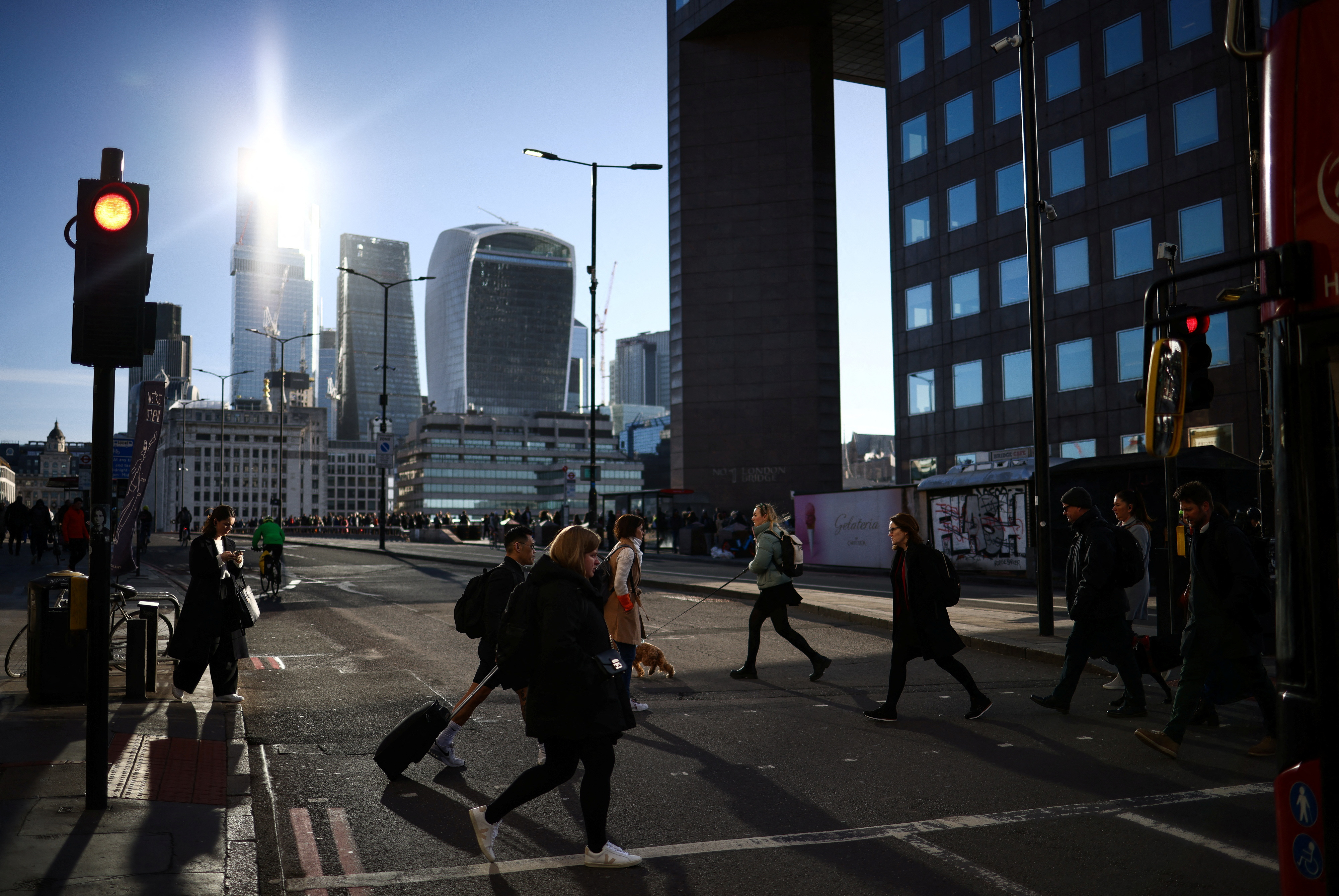 People cross the road on London Bridge during the morning rush hour
