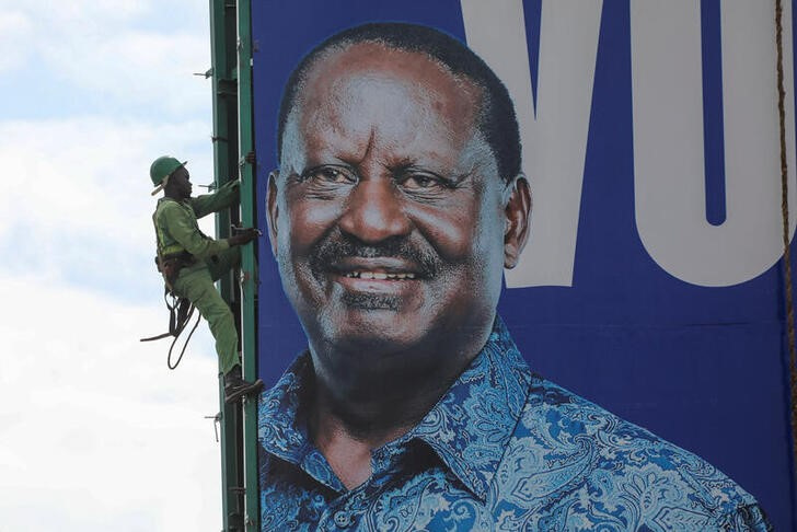Works take down a banner of Kenya's opposition leader and presidential candidate Raila Odinga of the Azimio La Umoja (Declaration of Unity) One Kenya Alliance, in Kisumu