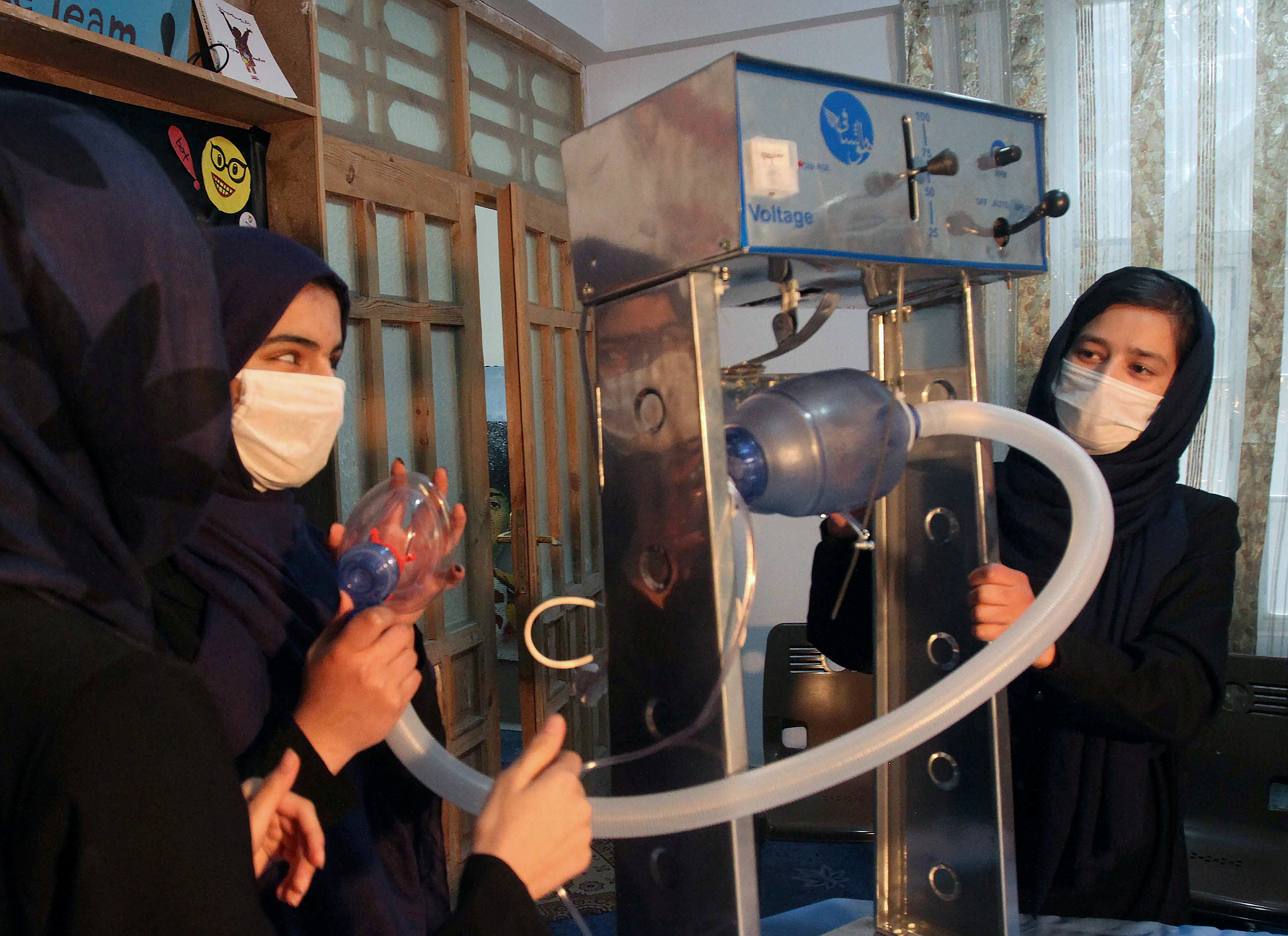 Members of an Afghan all-female robotics team work on an open-source and low-cost ventilator in Herat