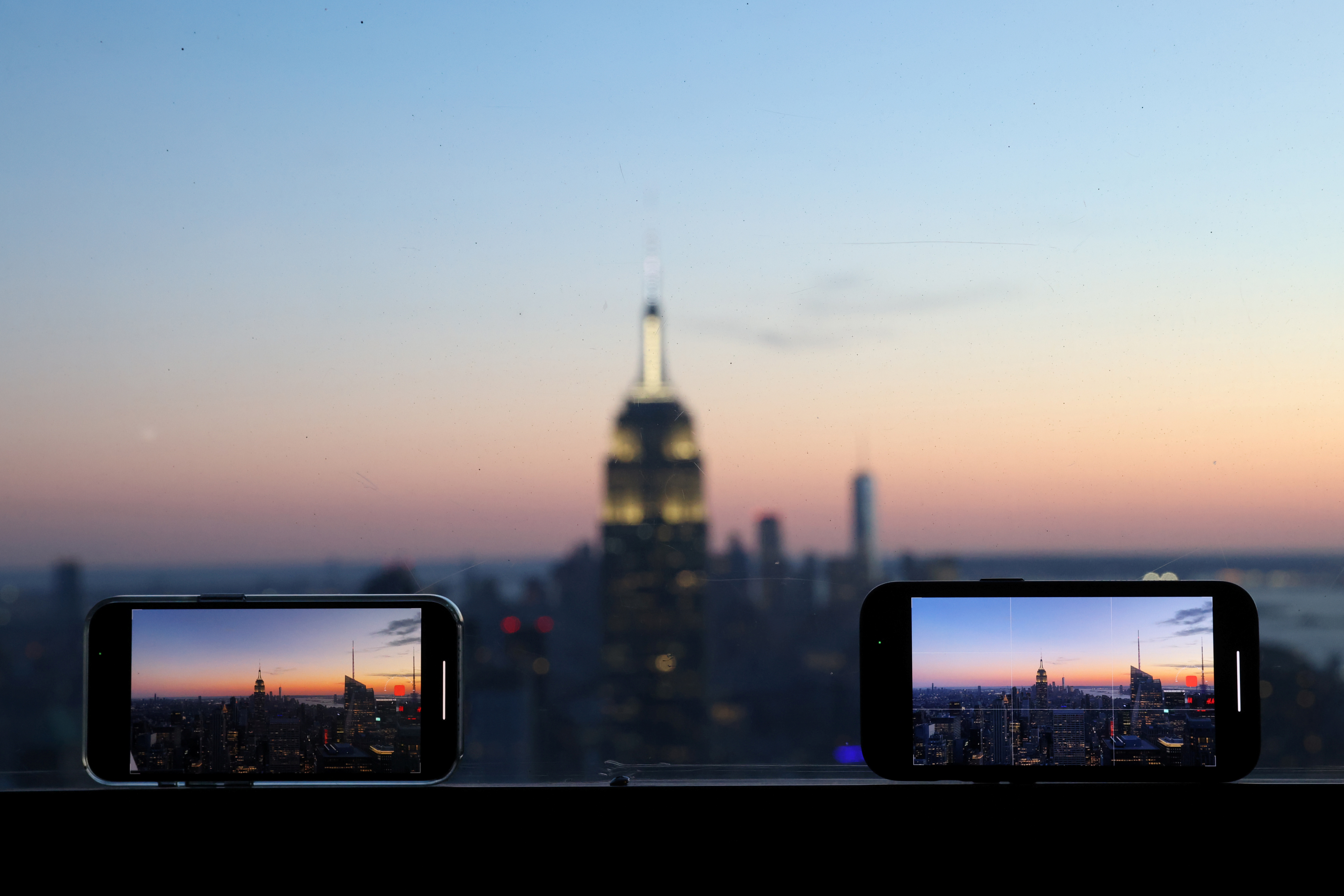 Smartphones are used to record the skyline at sunset in Manhattan, in New York City