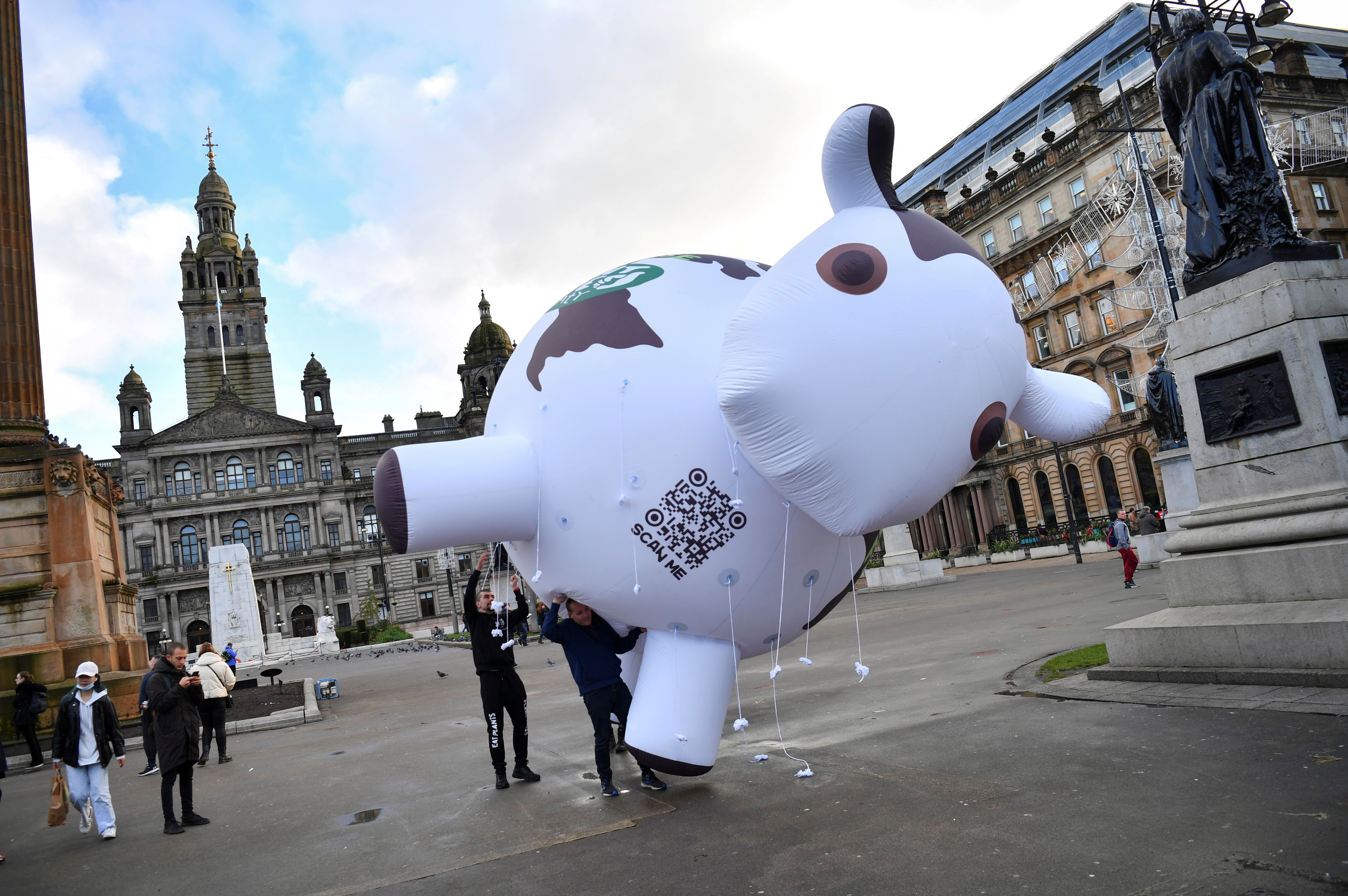 Activists attempt to carry an inflatable cow as they protest in favour of a plant based diet during a demonstration at George Square as the UN Climate Change Conference (COP26) takes place, in Glasgow, Scotland, Britain, November 9, 2021. REUTERS/Dylan Martinez/File Photo