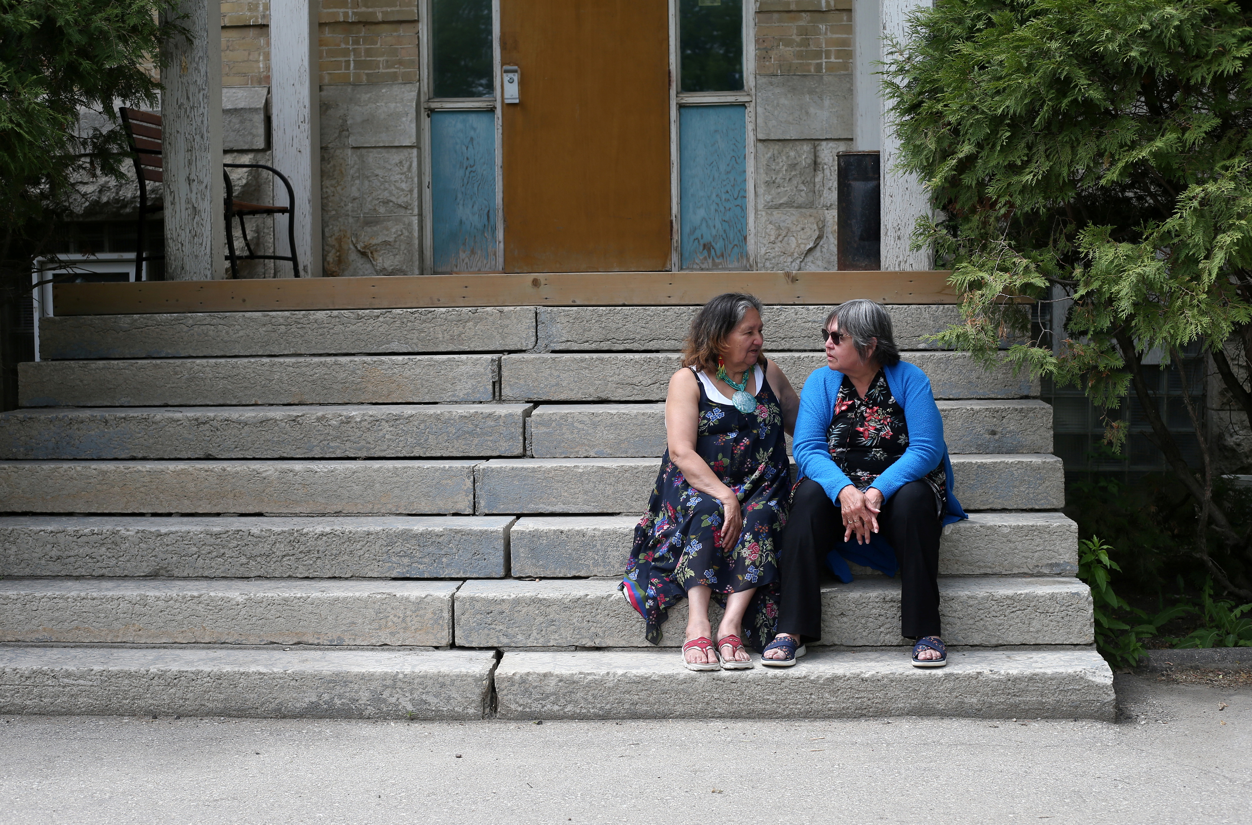 Daniels and Roulette talk on the steps of the former Portage La Prairie Indian Residential School in Canada