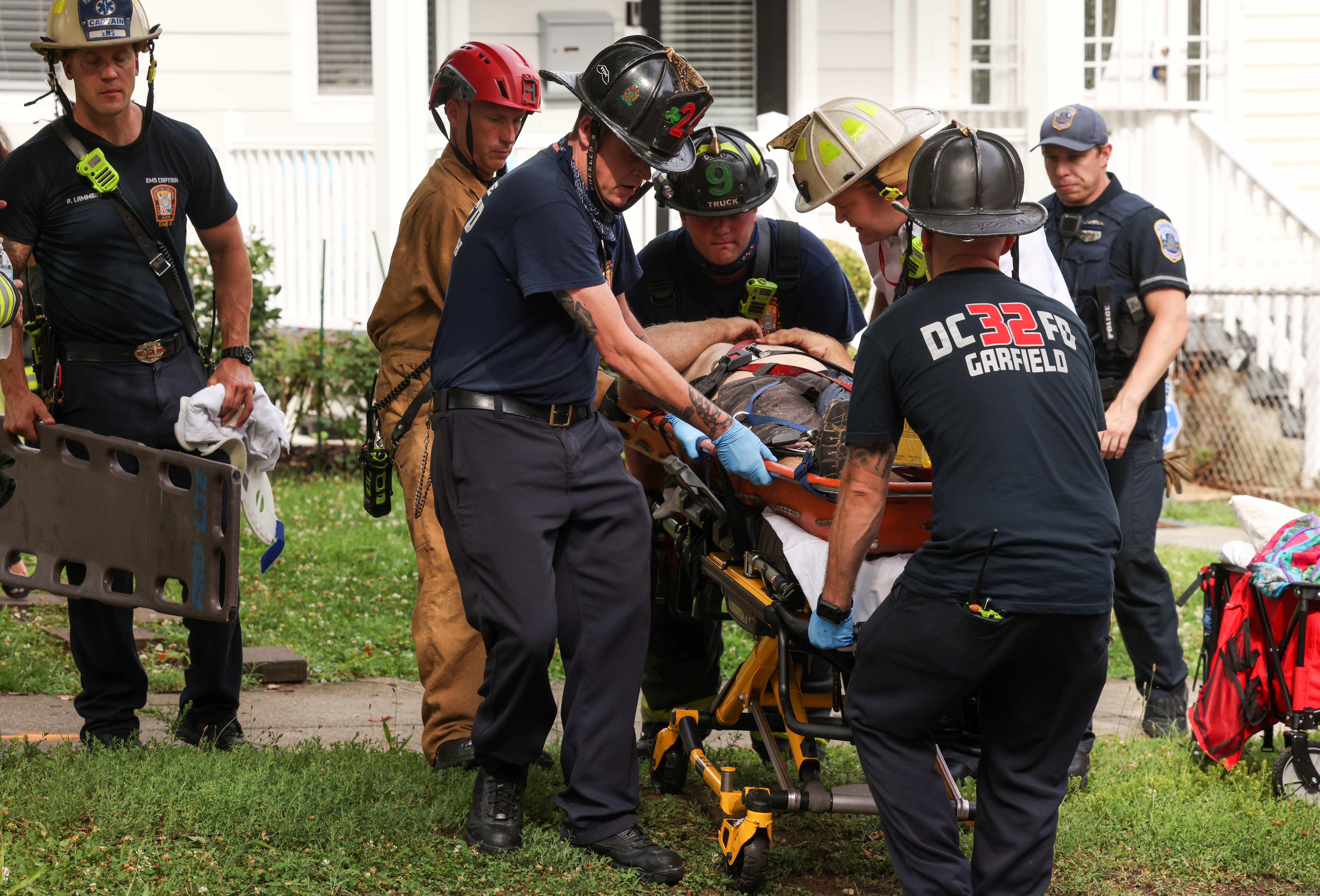 Emergency personnel place an injured construction worker into an ambulance for transport to the hospital after he was extricated from the debris after a building undergoing construction collapsed on Kennedy Street in Washington, U.S., July 1, 2021. REUTERS/Evelyn Hockstein