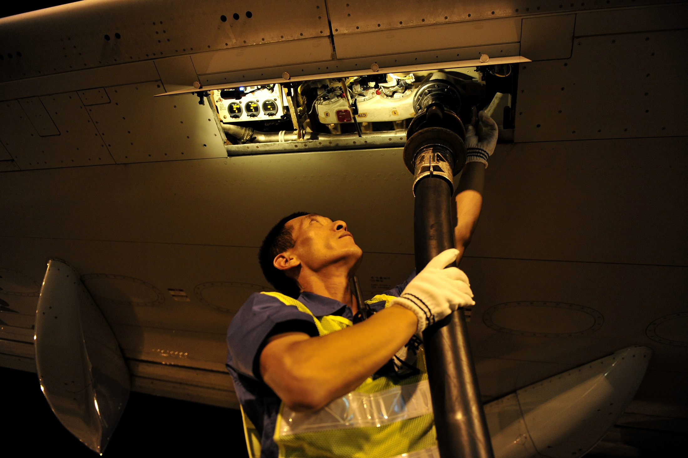 Worker refuels a Dalian Airlines aircraft with aviation fuel at an airport in Hohhot