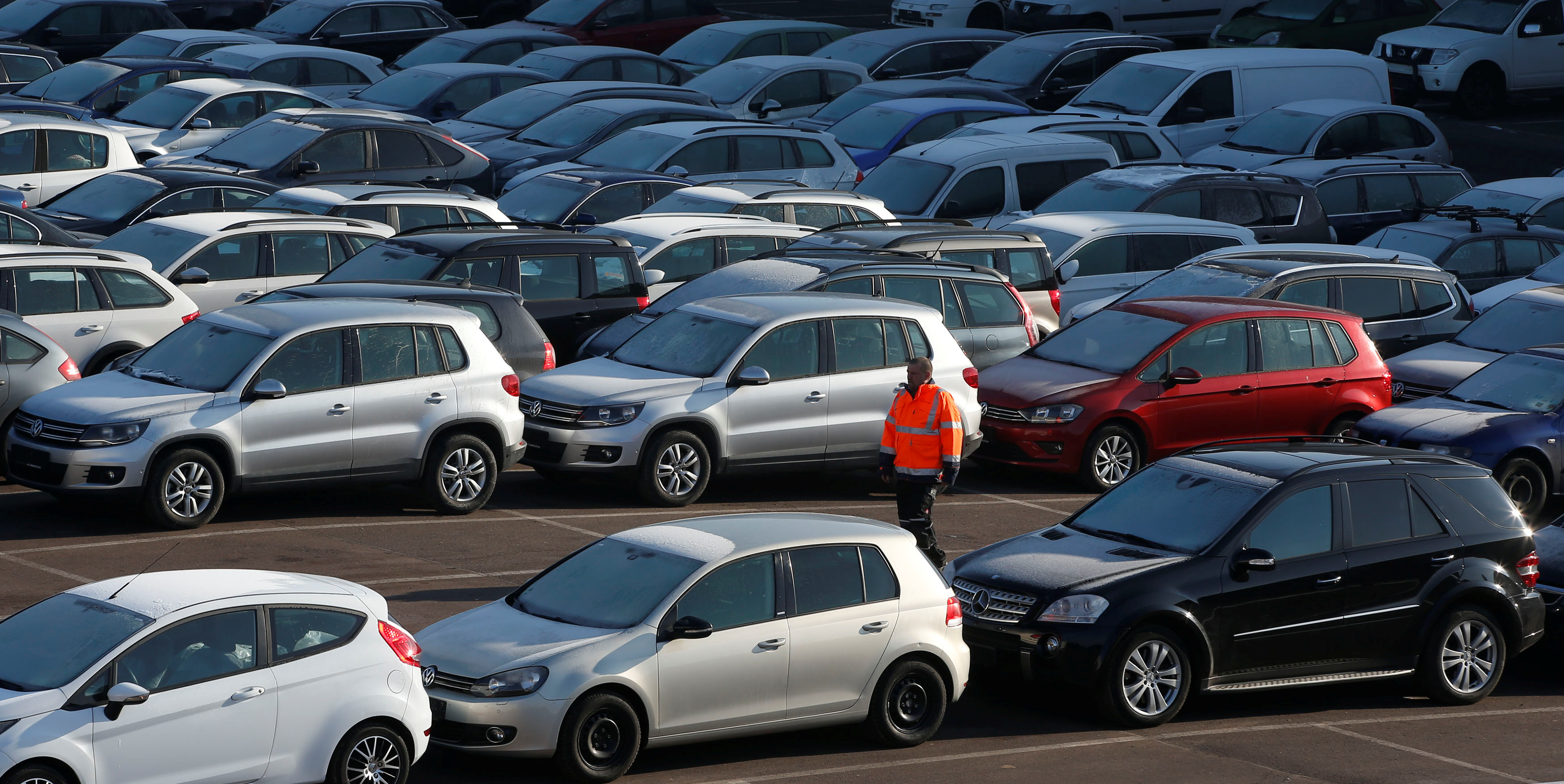 A worker poses as he walks between second hand cars at the Auto1.com company grounds in Zoerbig