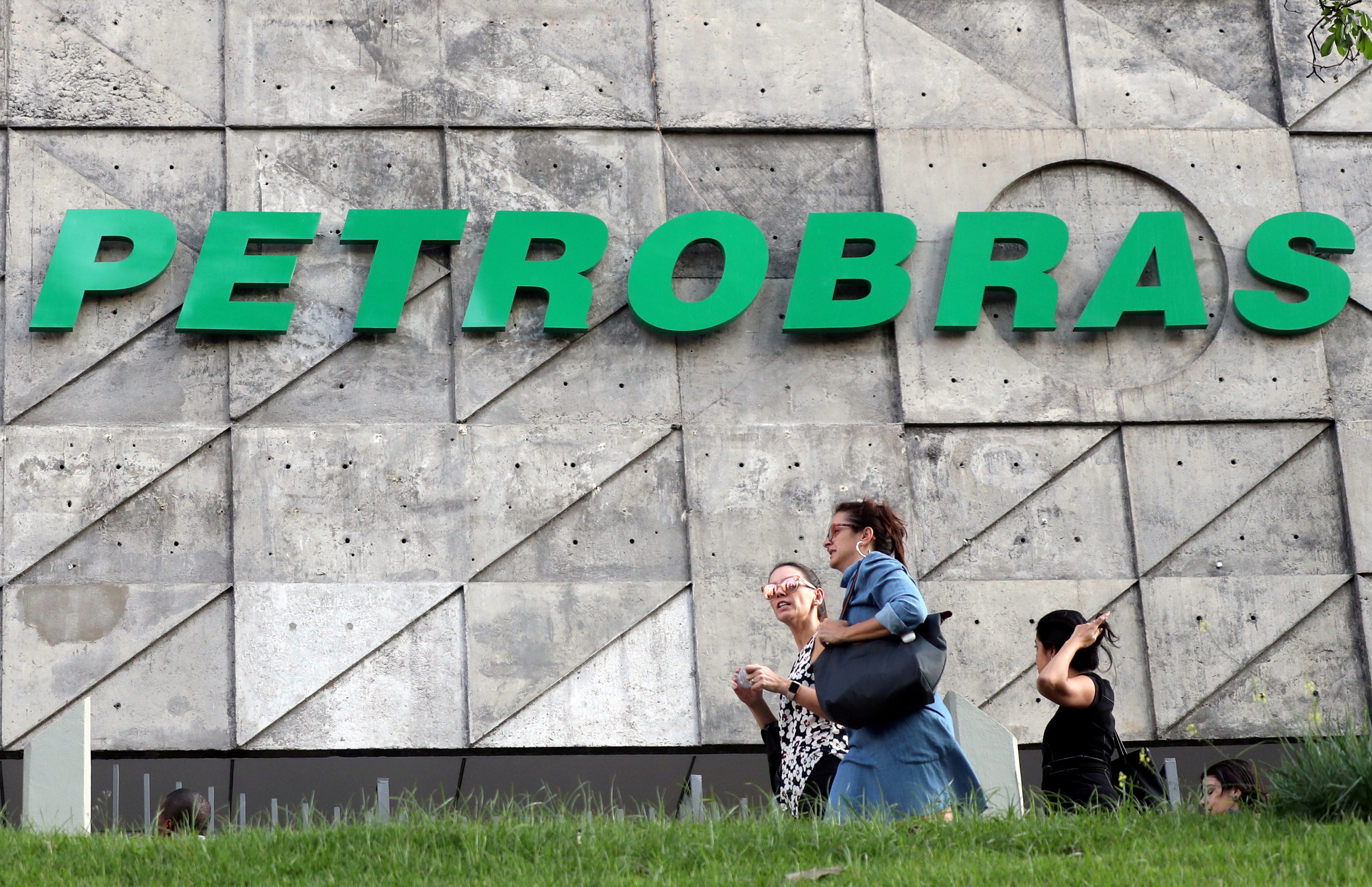People walk in front of the Brazil's state-run Petrobras oil company headquarters in Rio de Janeiro