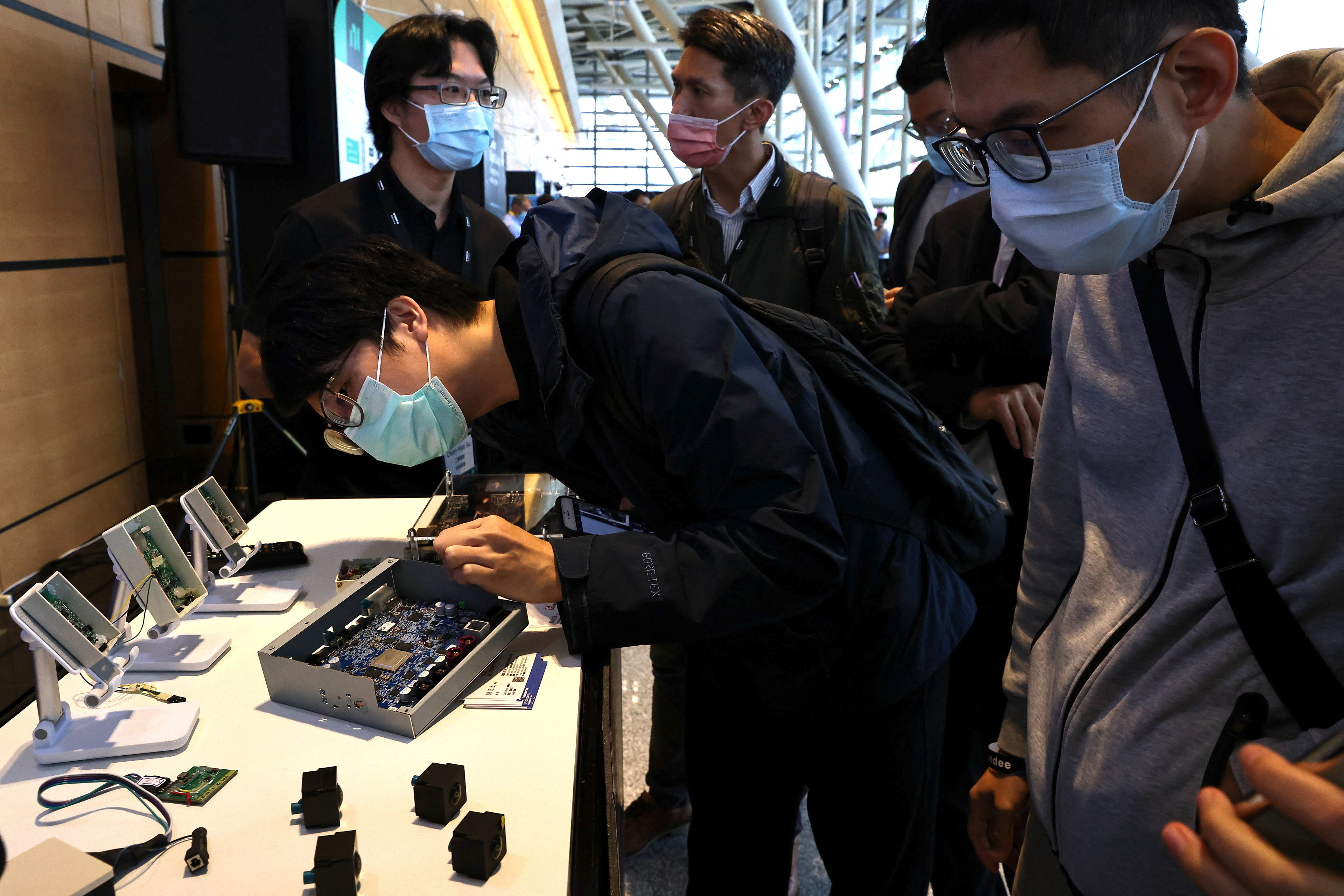 A person examines components used in electric vehicle at the Foxconn's EV development platform MIH demo day, in Taipei
