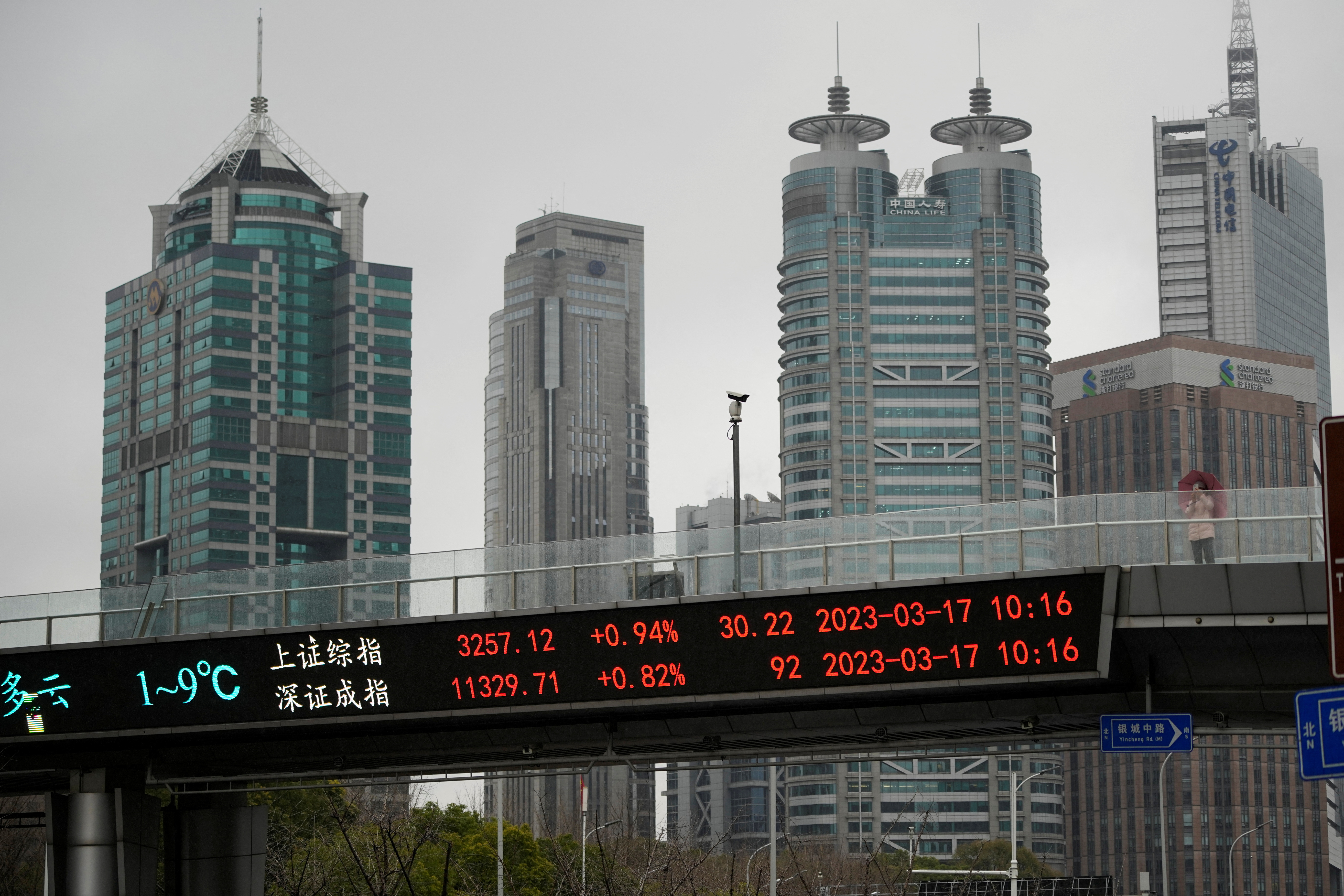 An electronic board shows Shanghai and Shenzhen stock indices at the Lujiazui financial district in Shanghai
