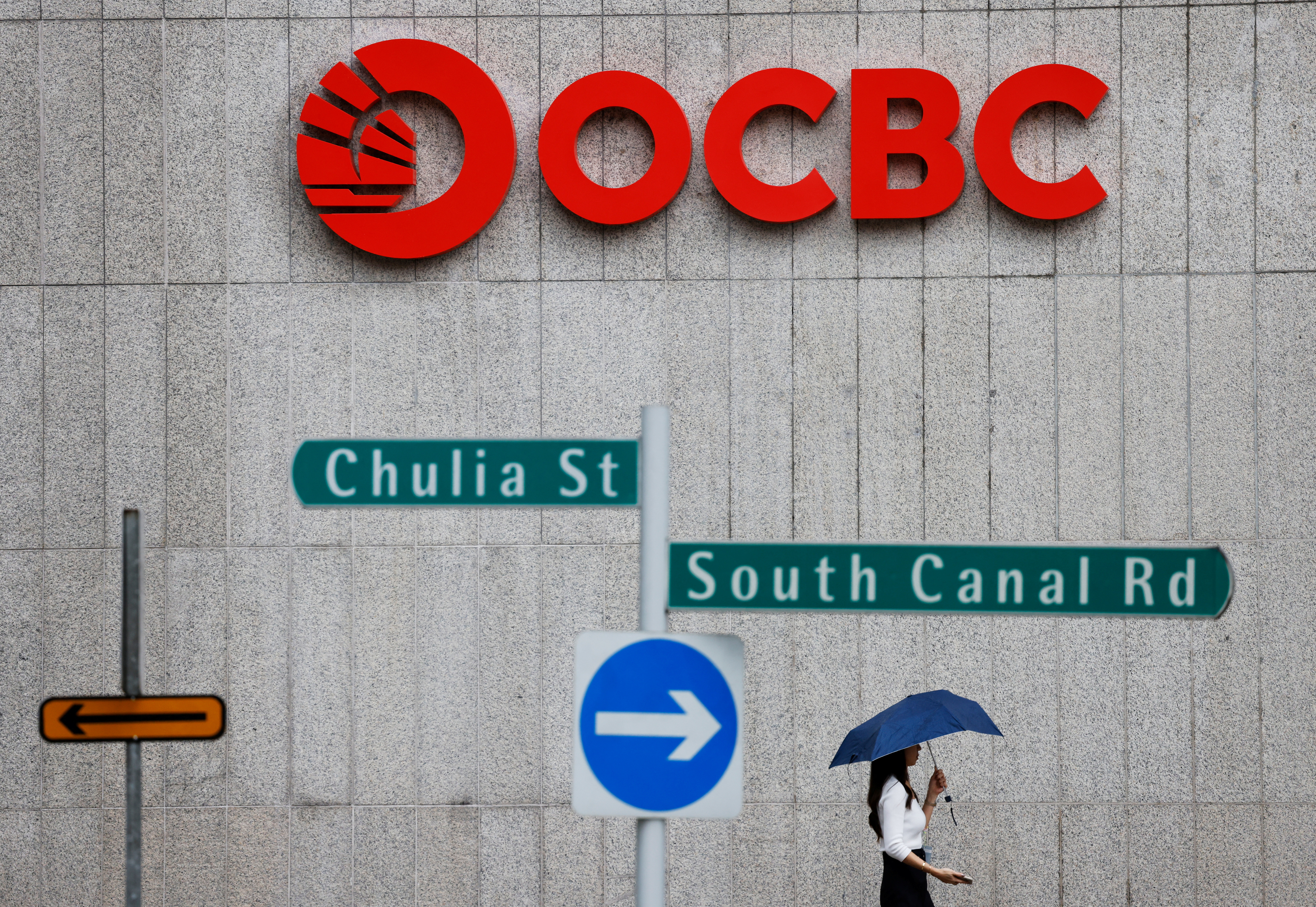 People pass an OCBC Bank signage in Singapore