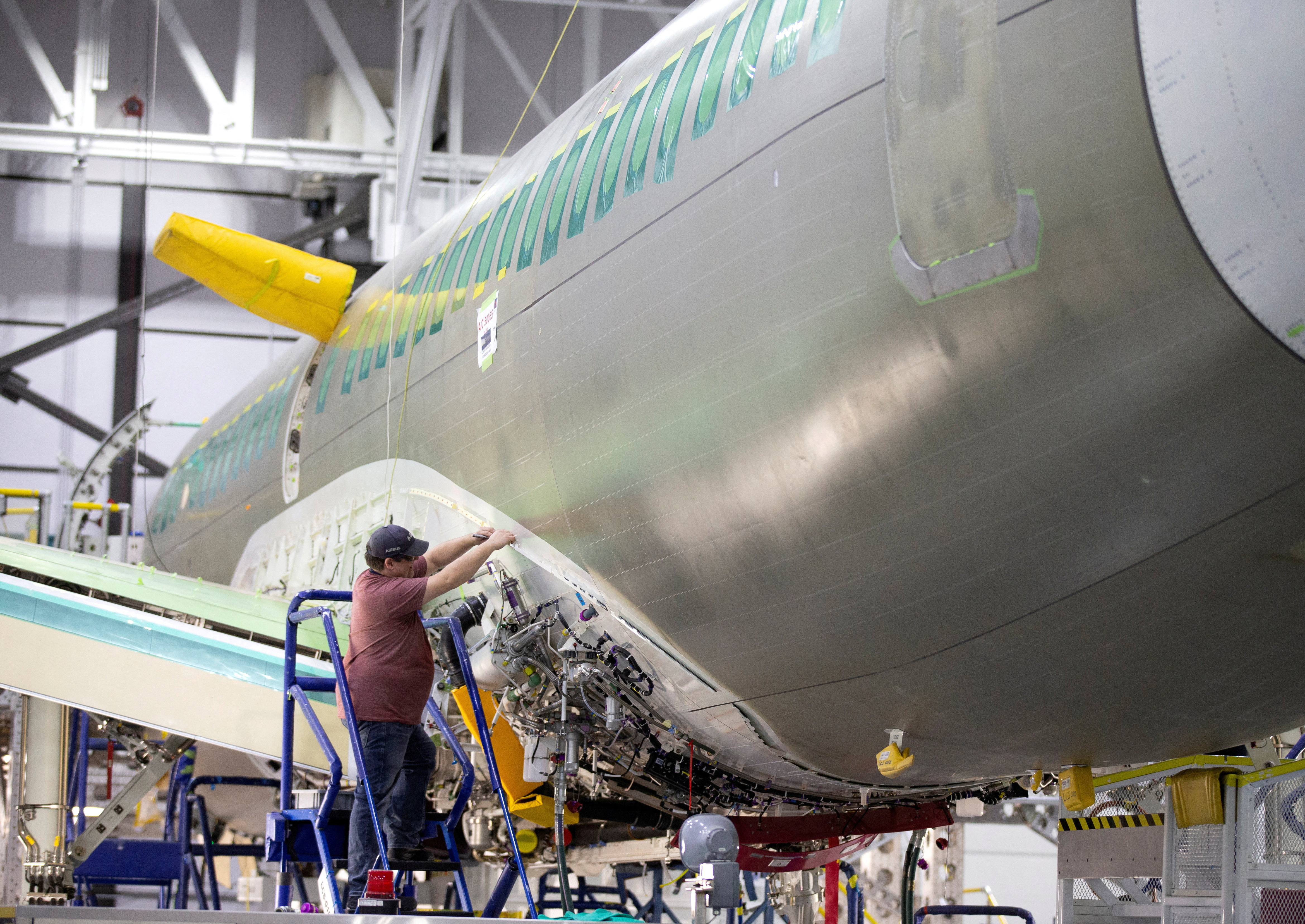 An employee works on an Airbus A220-300 at their facility in Mirabel