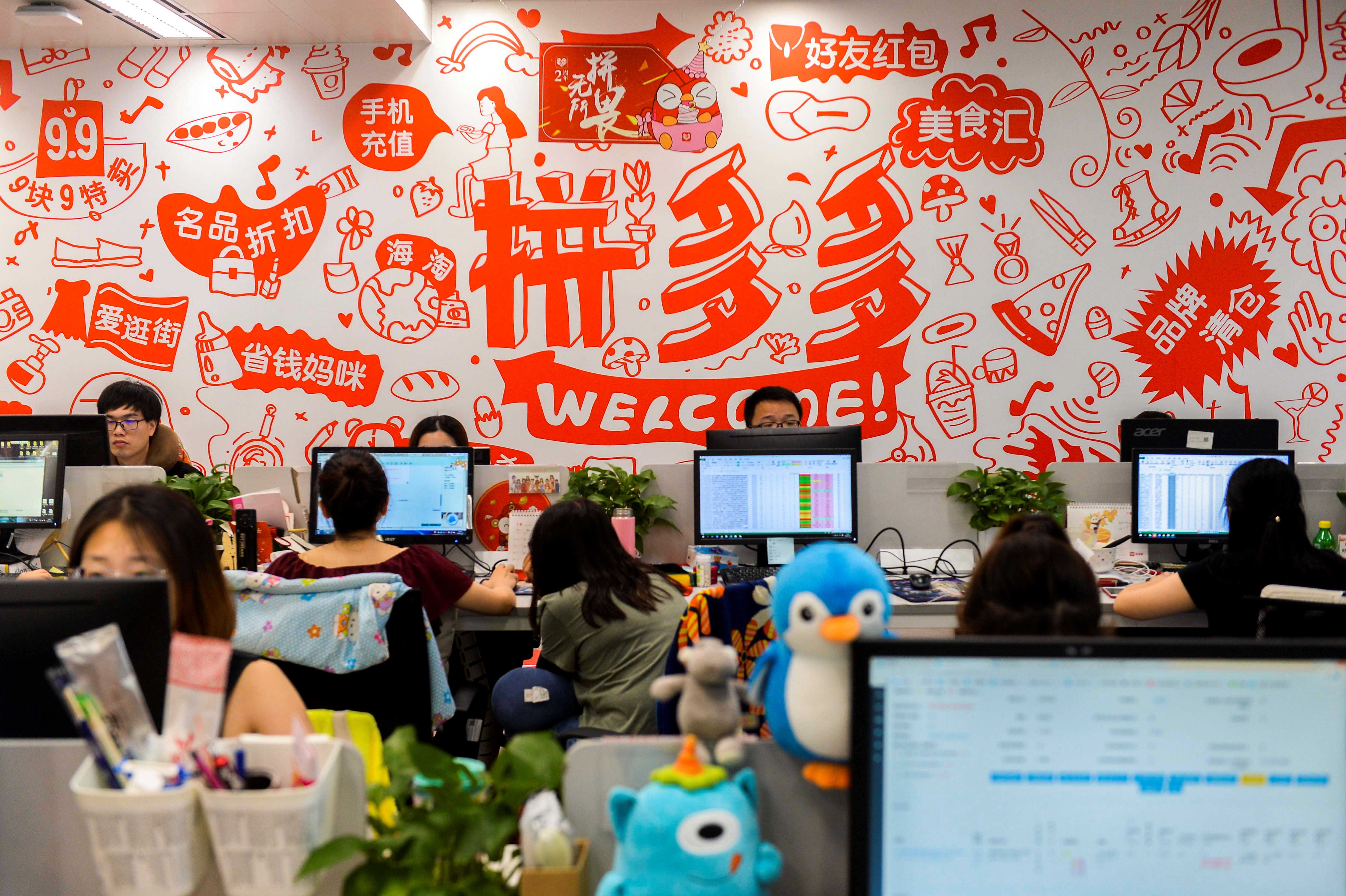 People are seen at their desks at the headquarters of Chinese online group discounter Pinduoduo in Shanghai