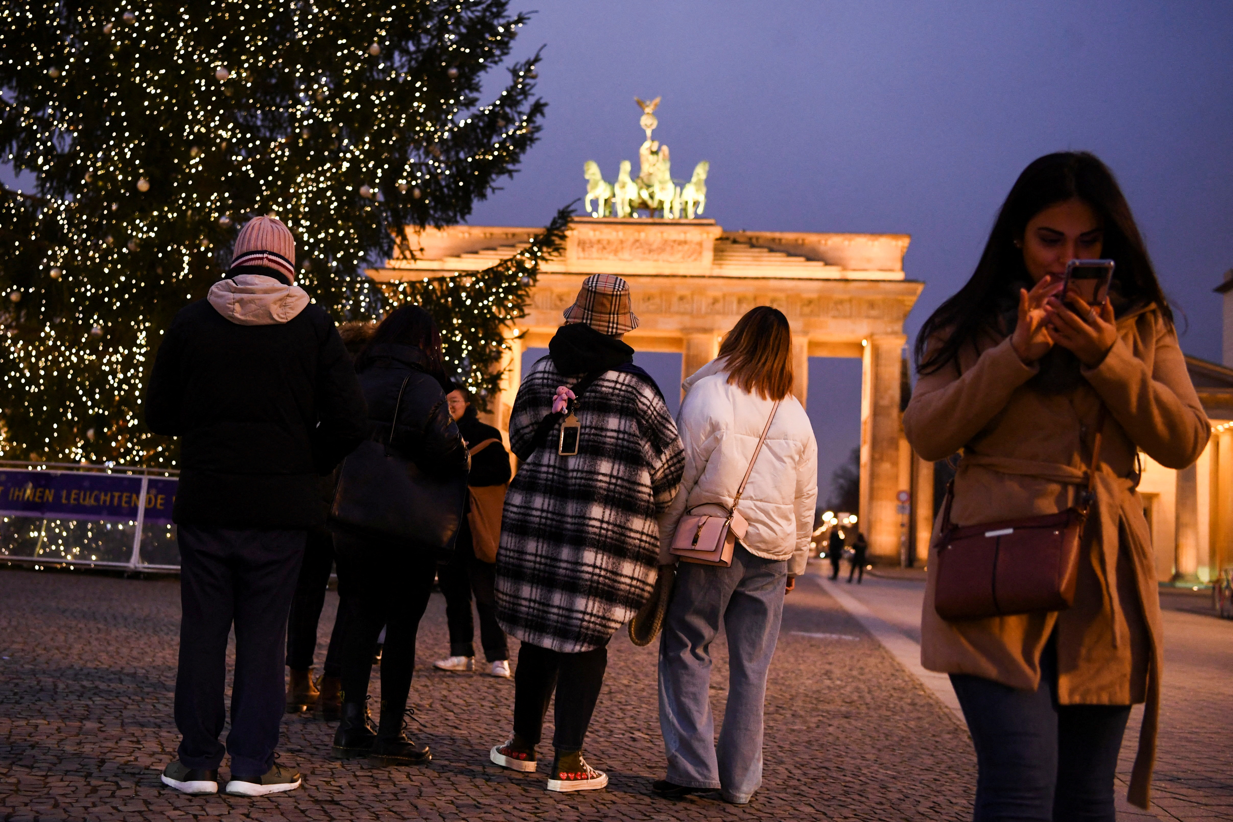 People pass by a Christmas tree close to Brandenburg gate in Berlin