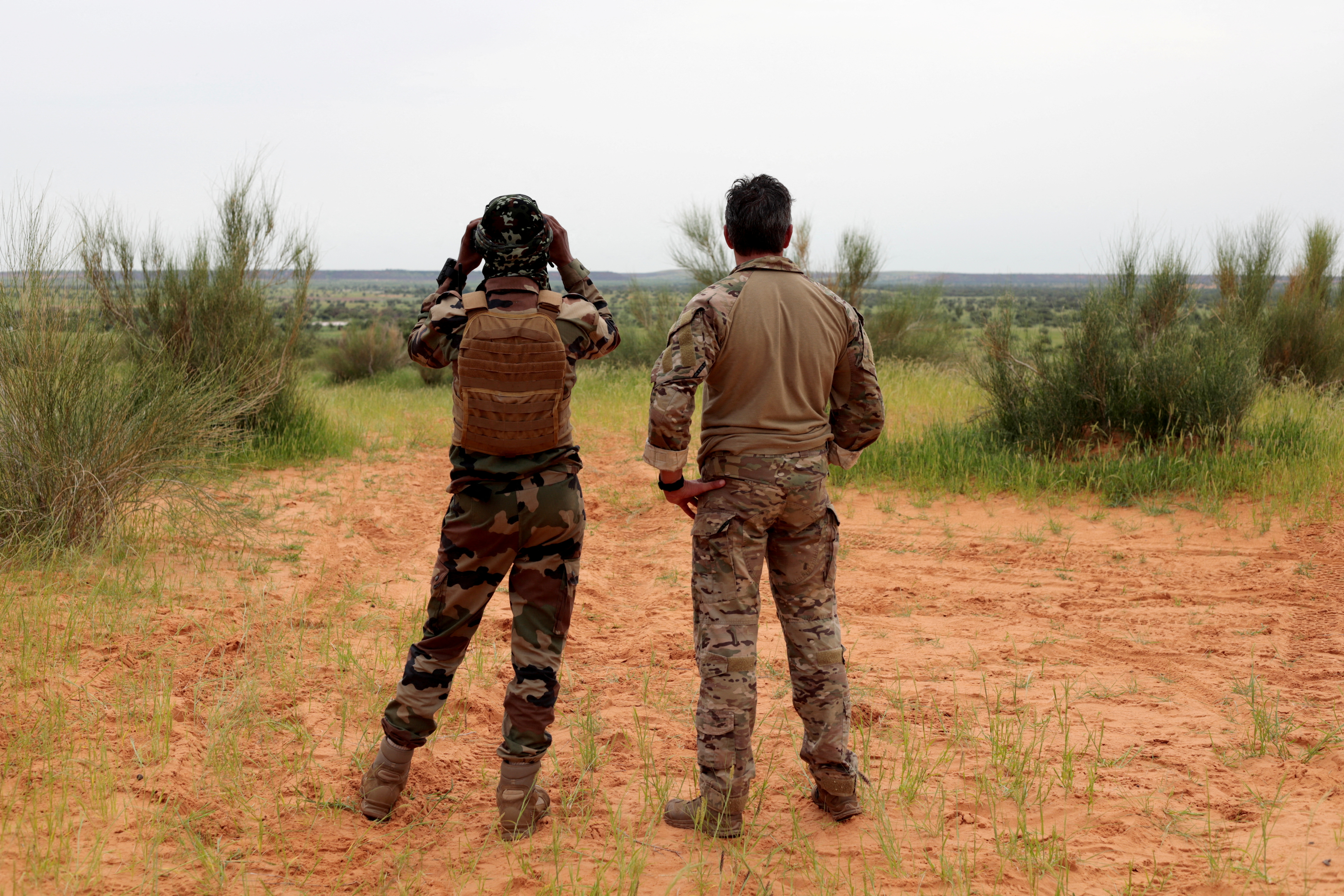 A soldier from the new Takuba force stands with a Malian soldier during a patrol near Niger border in Dansongo Circle
