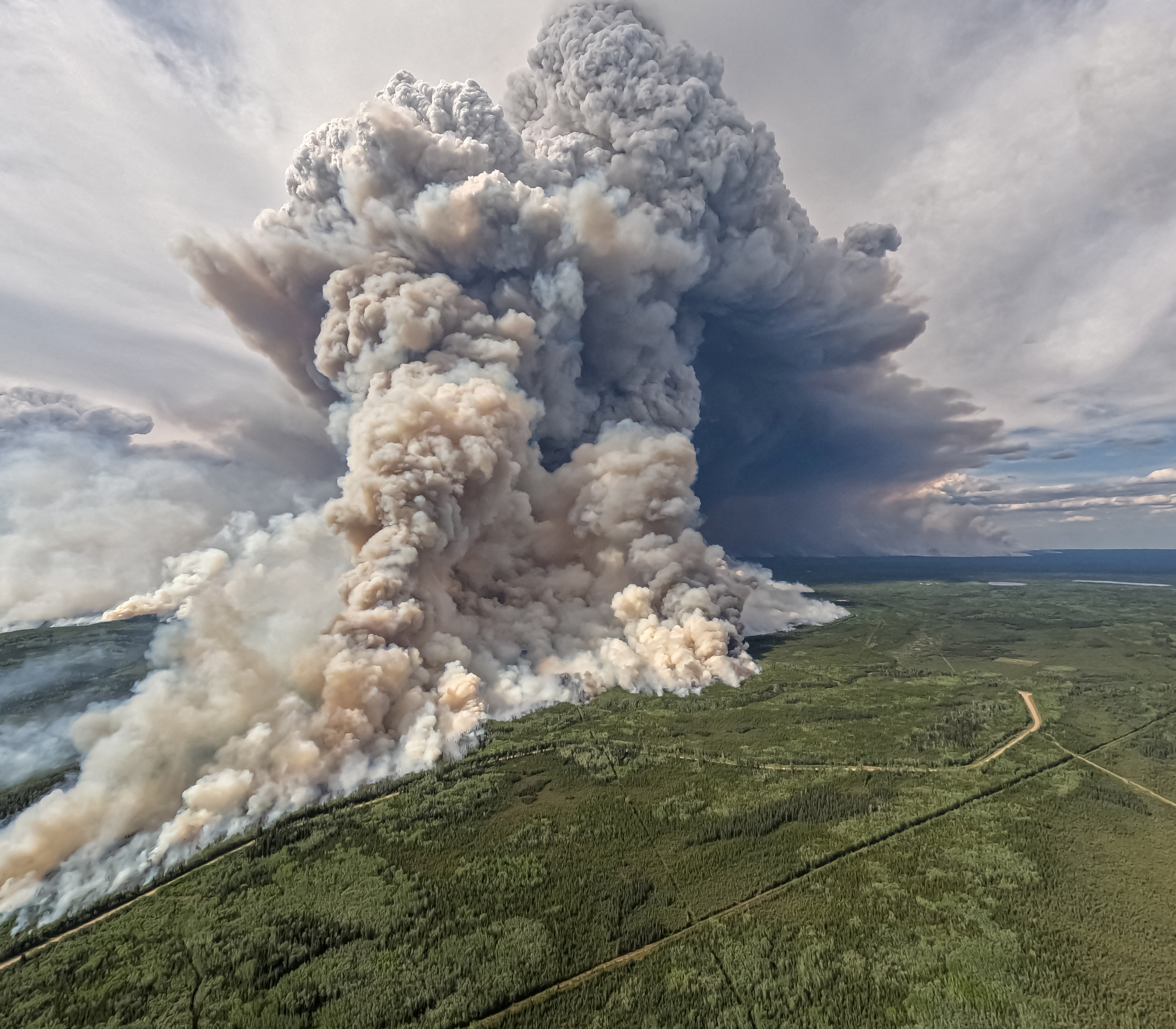 Smoke billows upwards from a planned ignition by firefighters tackling the Donnie Creek Complex wildfire south of Fort Nelson