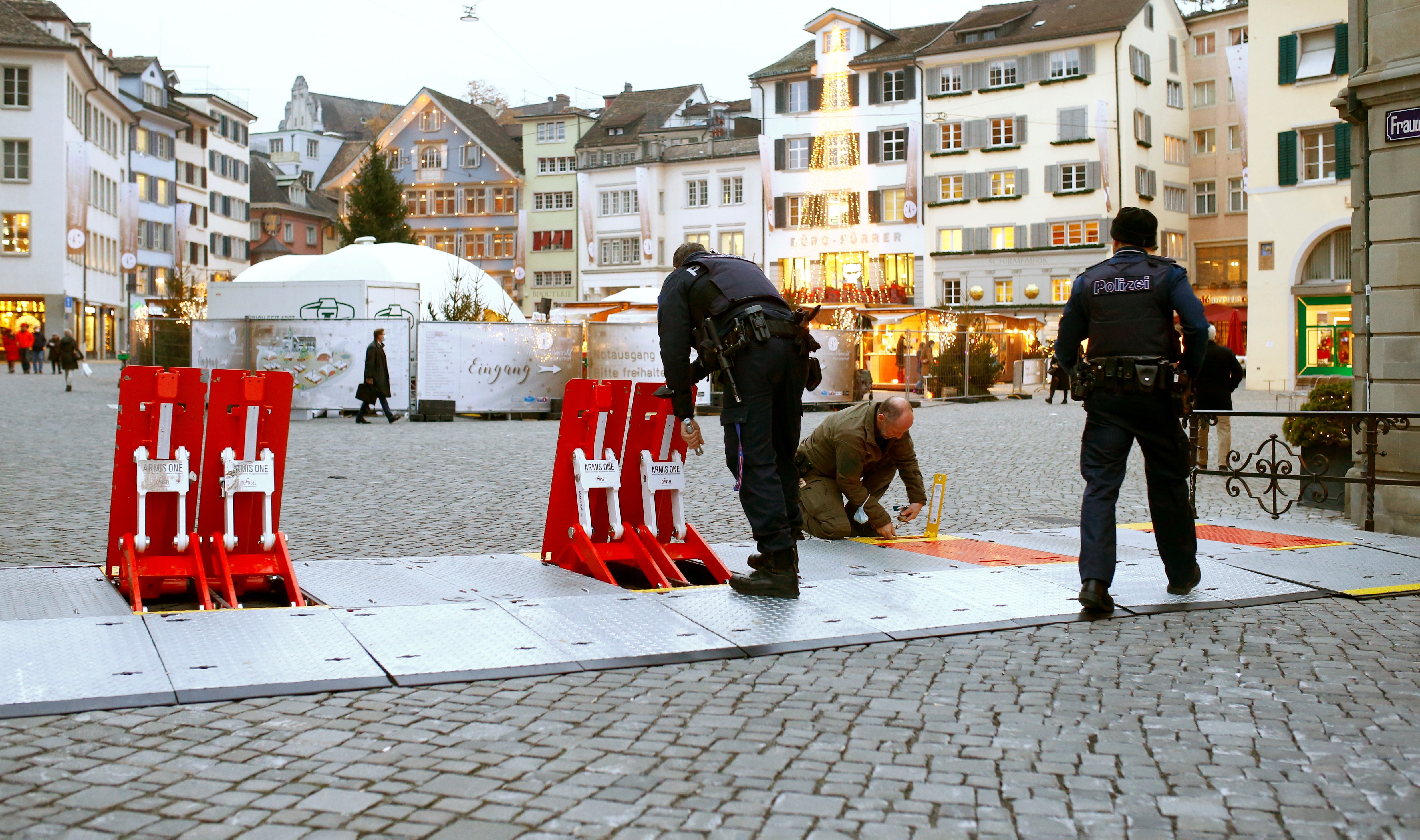 Swiss police officers prepare mobile barriers blocking a street to protect a Christmas market on the Muensterhof square in Zurich, Switzerland November 25, 2021. REUTERS/Arnd Wiegmann