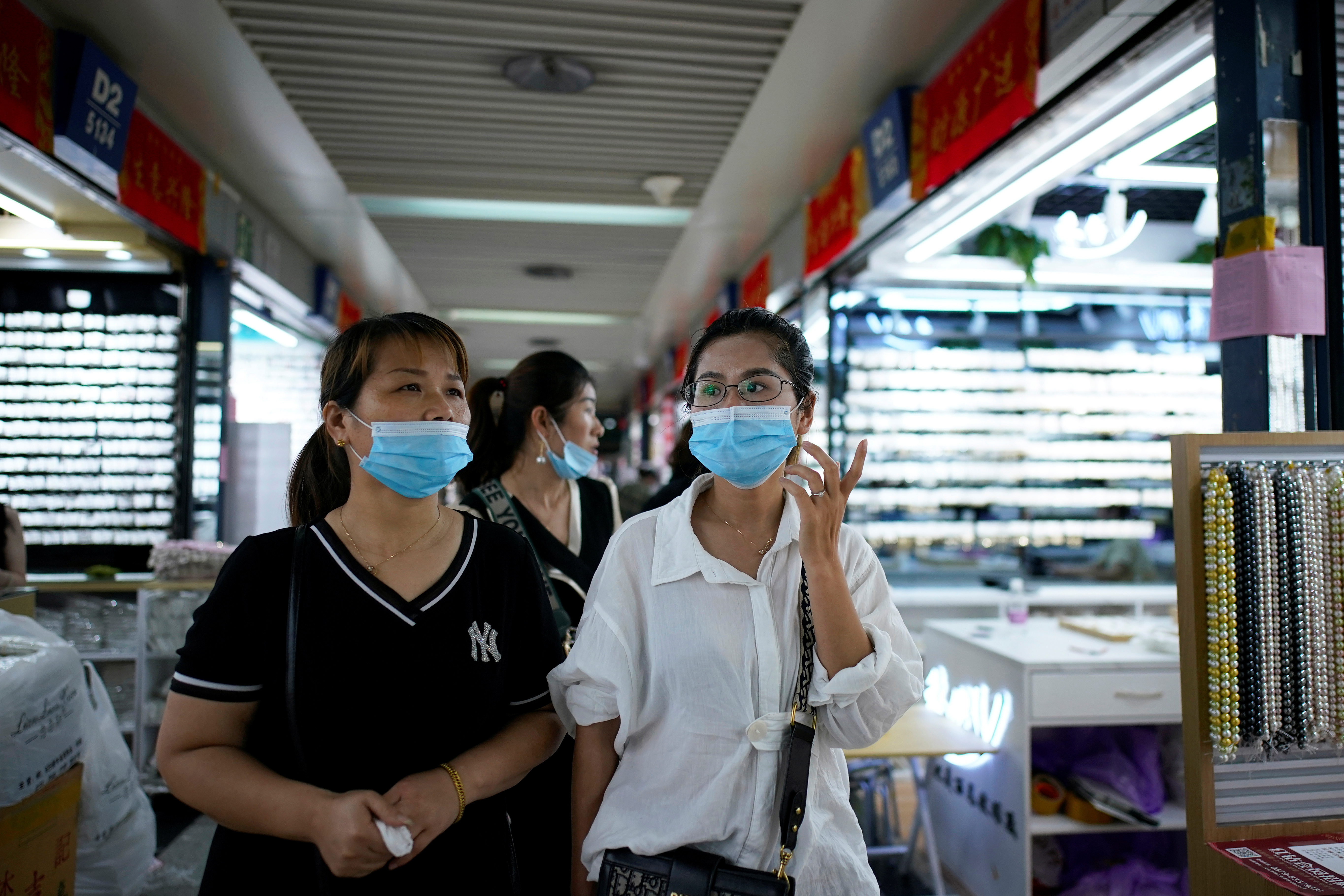 Women wearing face masks talk at the Yiwu Wholesale Market following an outbreak of the novel coronavirus disease (COVID-19), in Yiwu