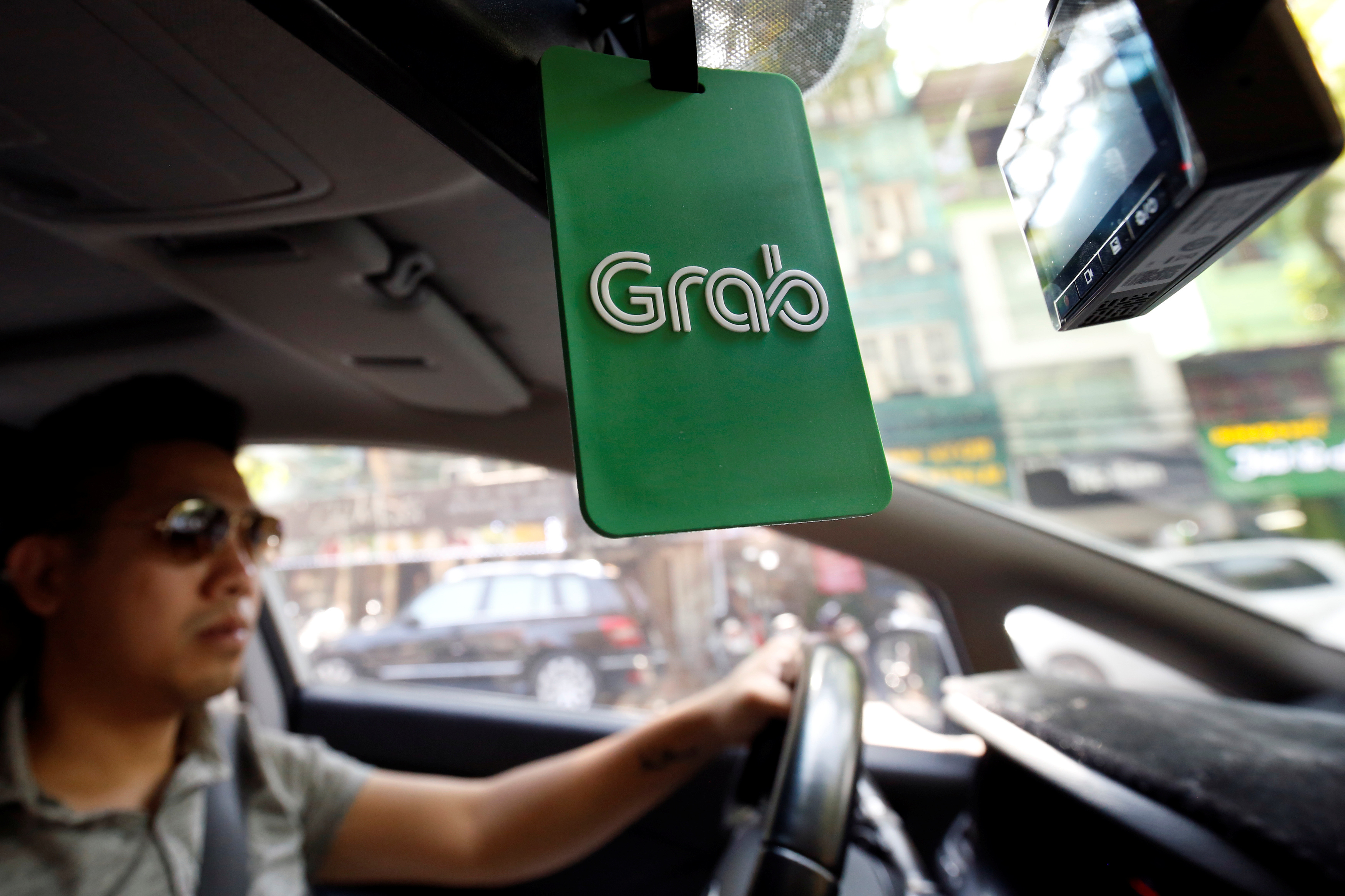 A Grab taxi drives on a street in Hanoi