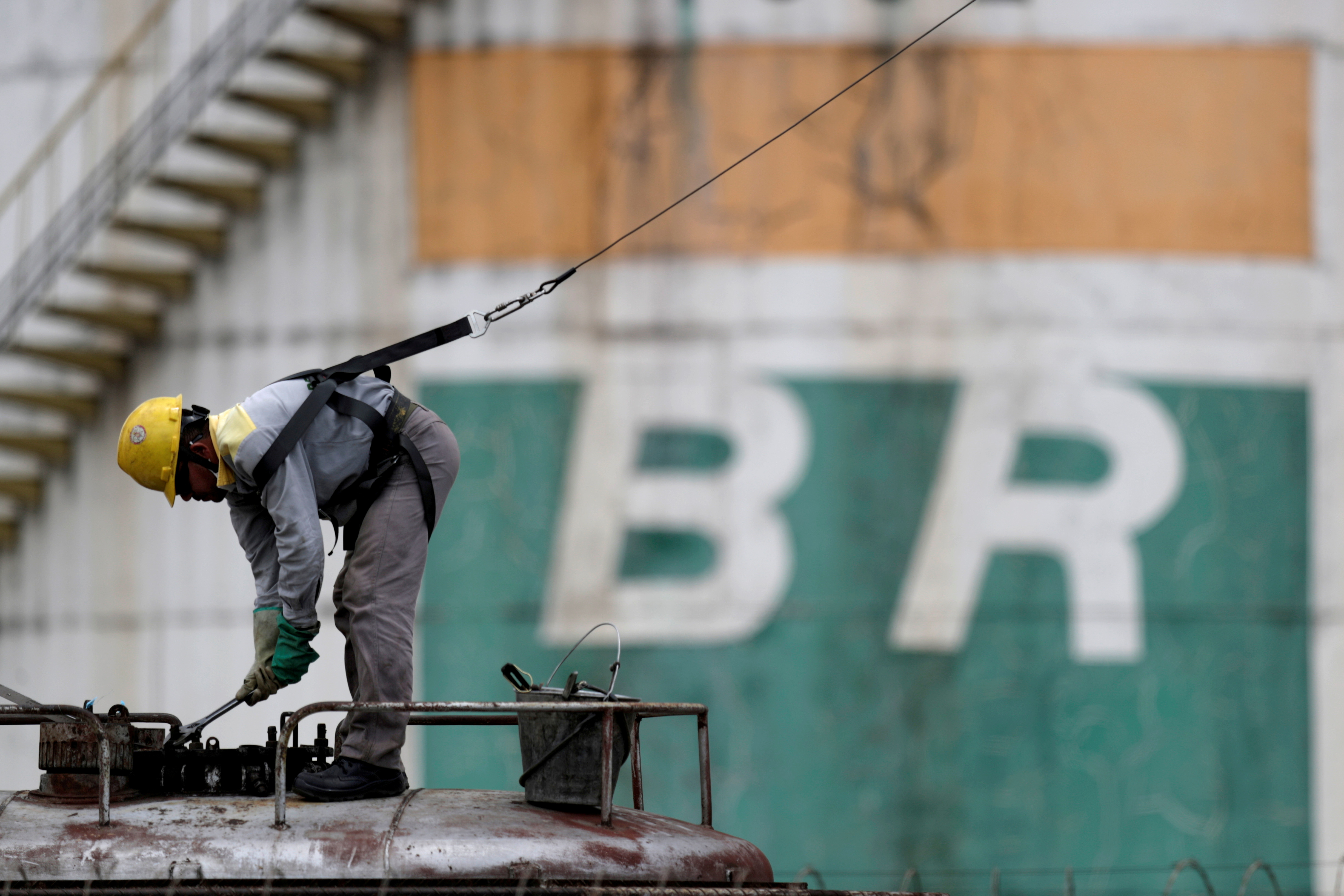 FILE PHOTO: FILE PHOTO: A worker checks the fuel volumes on a train wagon near a tank of Brazil's state-run Petrobras oil company in Brasilia, Brazil