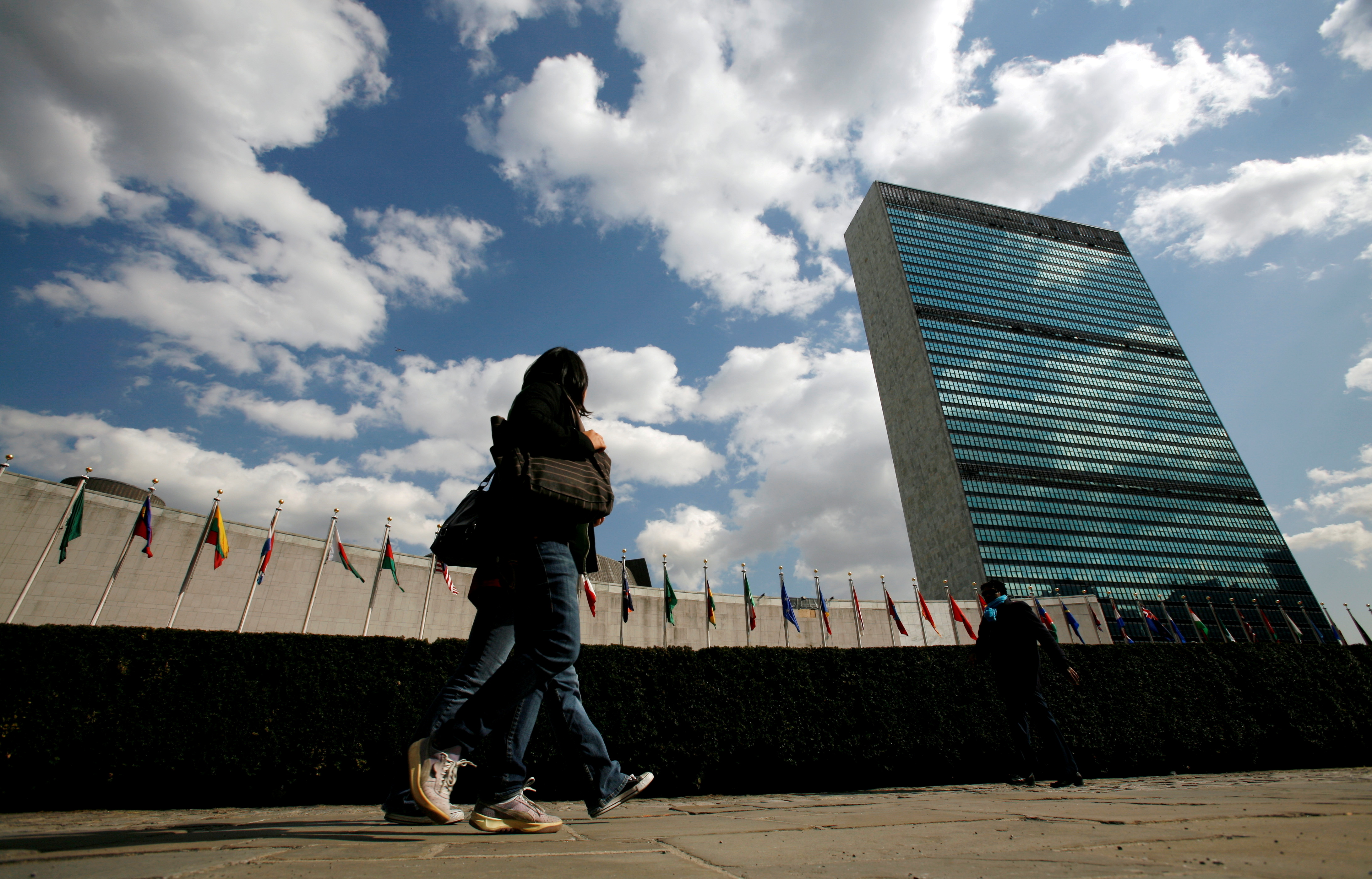 Tourists pass United Nations Headquarters in New York