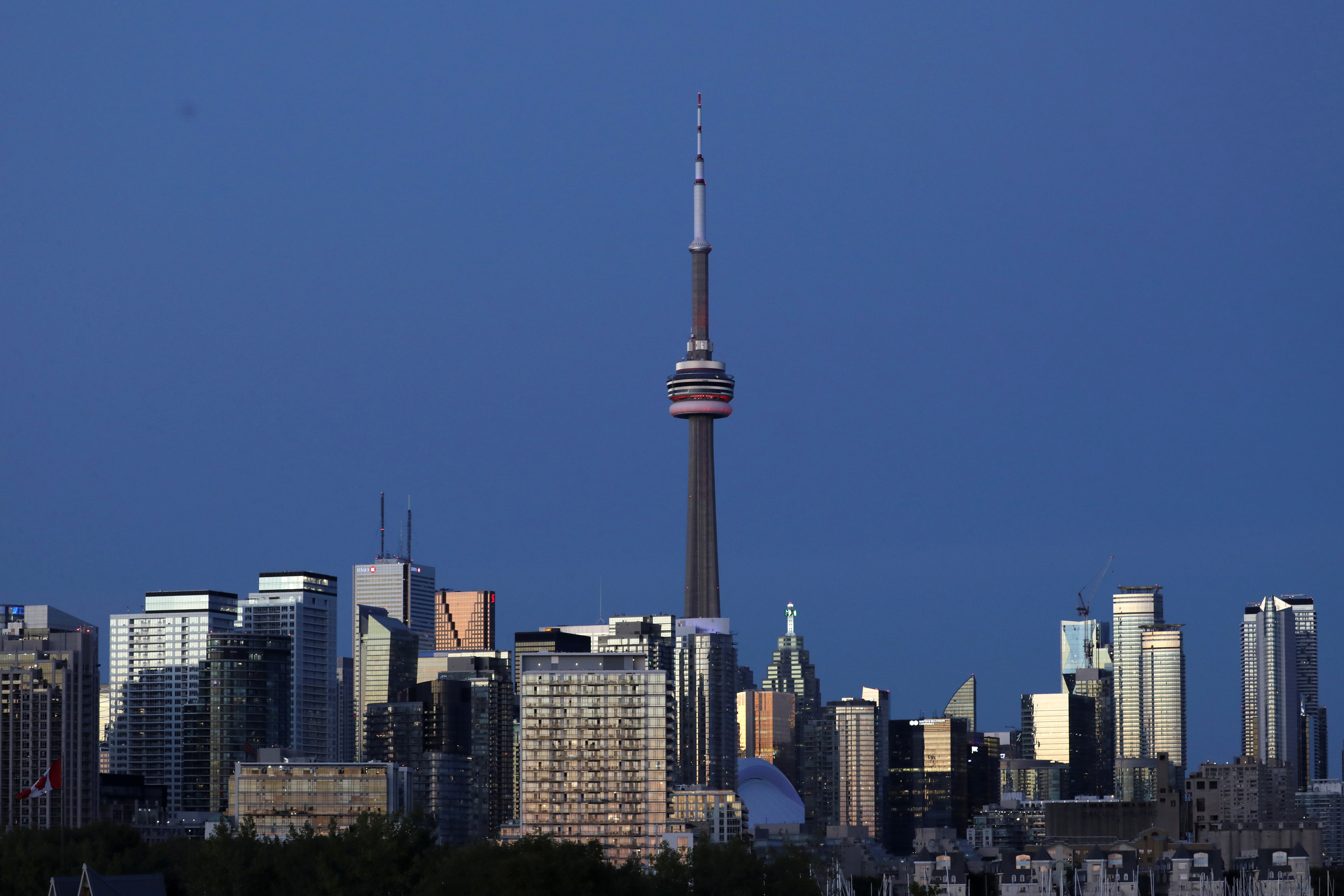The CN Tower stands at dusk above office buildings and condominiums in the downtown core of Toronto