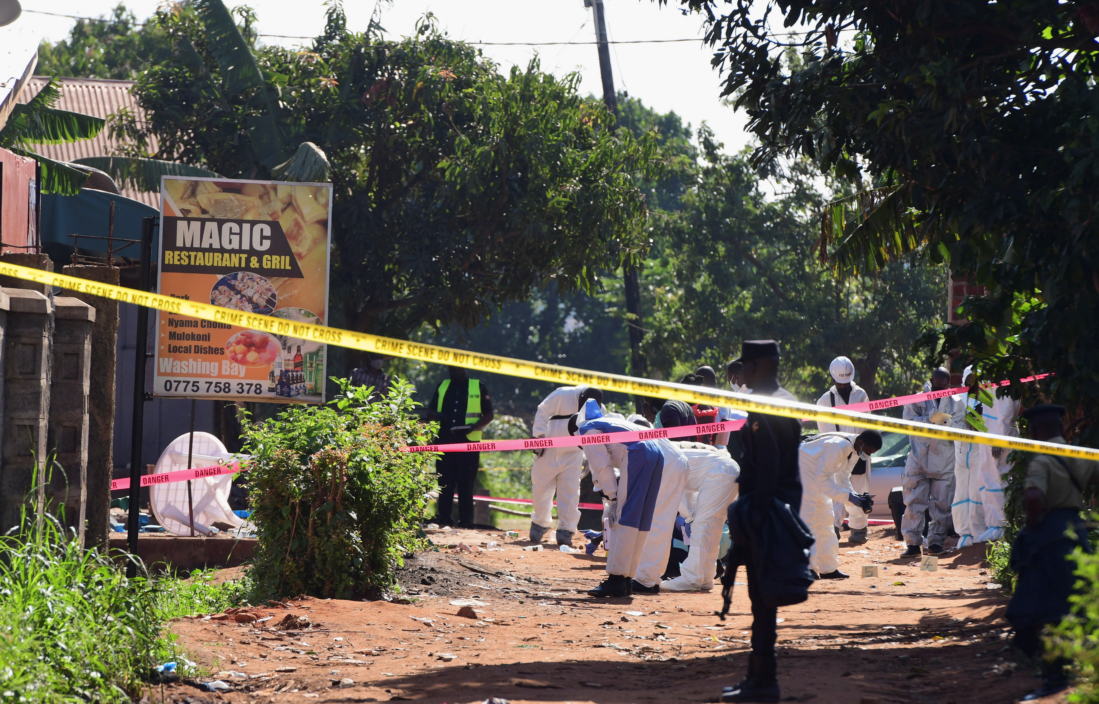 Ugandan police members and explosives experts secure the scene of an explosion in Komamboga, a suburb on the northern outskirts of Kampala, Uganda October 24, 2021. REUTERS/Abubaker Lubowa