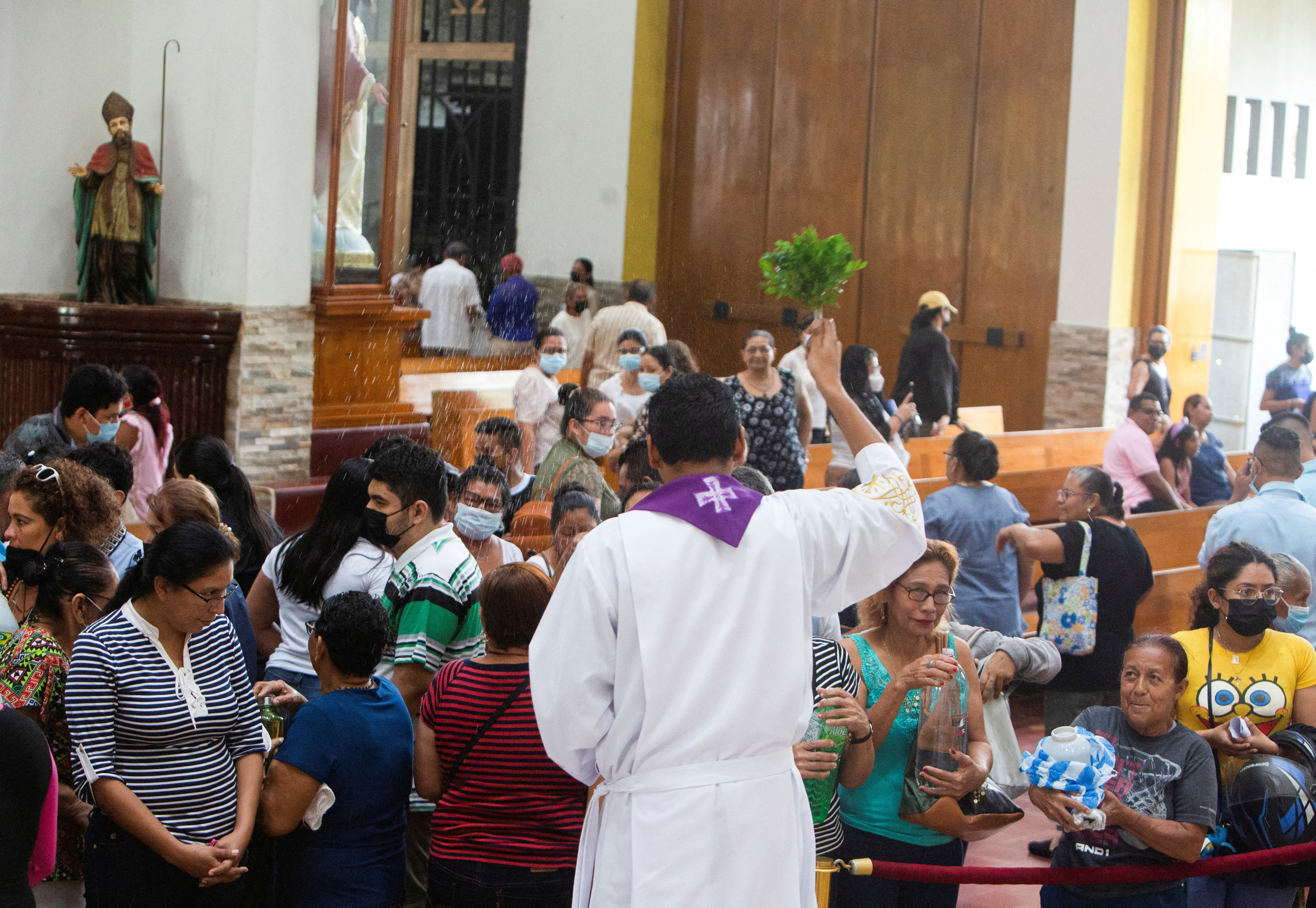 A bishop sprinkles water on the catholic parishioners at the Metropolitan Cathedral, in Managua