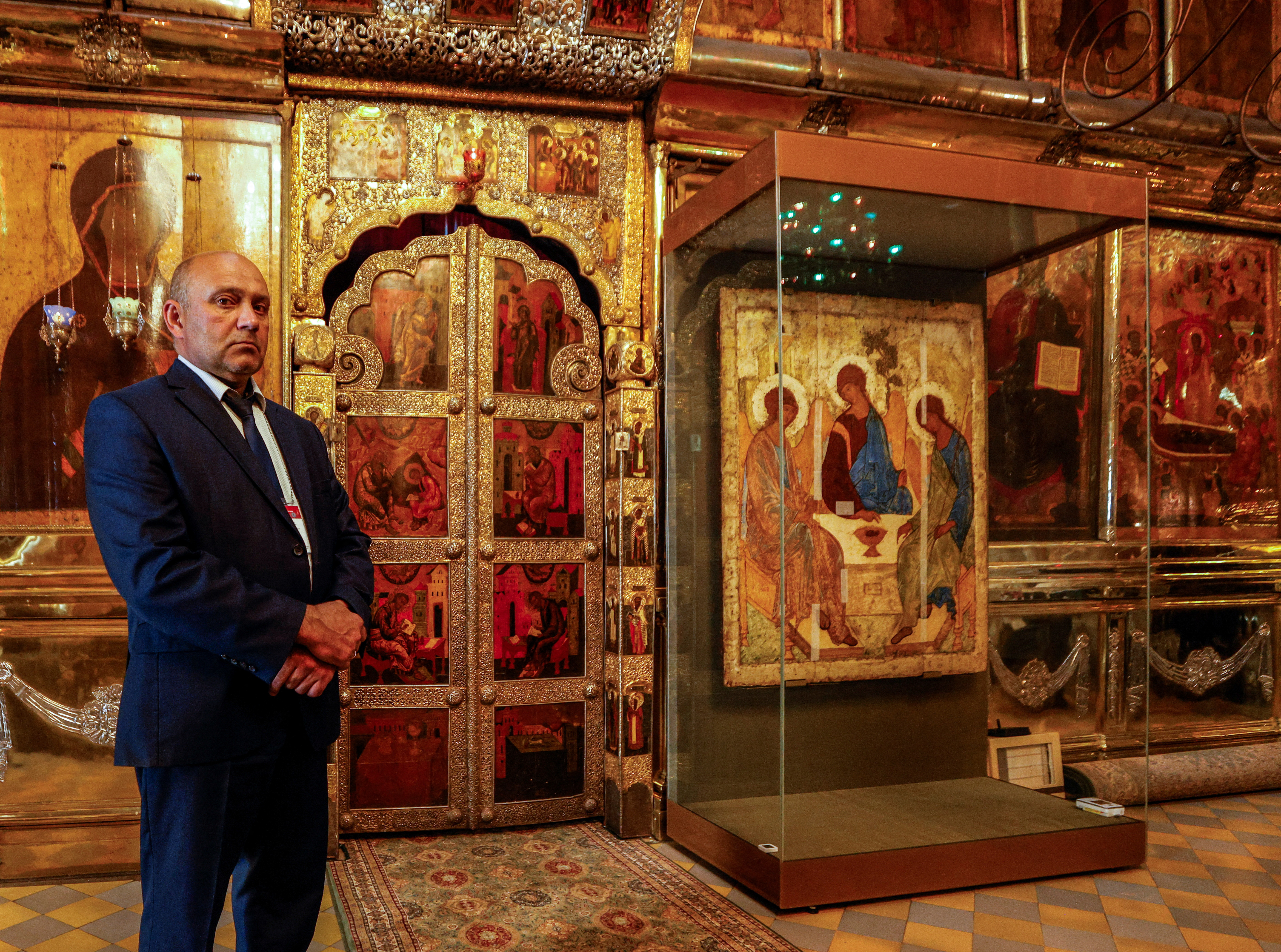A security guard stands next to the Trinity icon at a cathedral in Sergiyev Posad