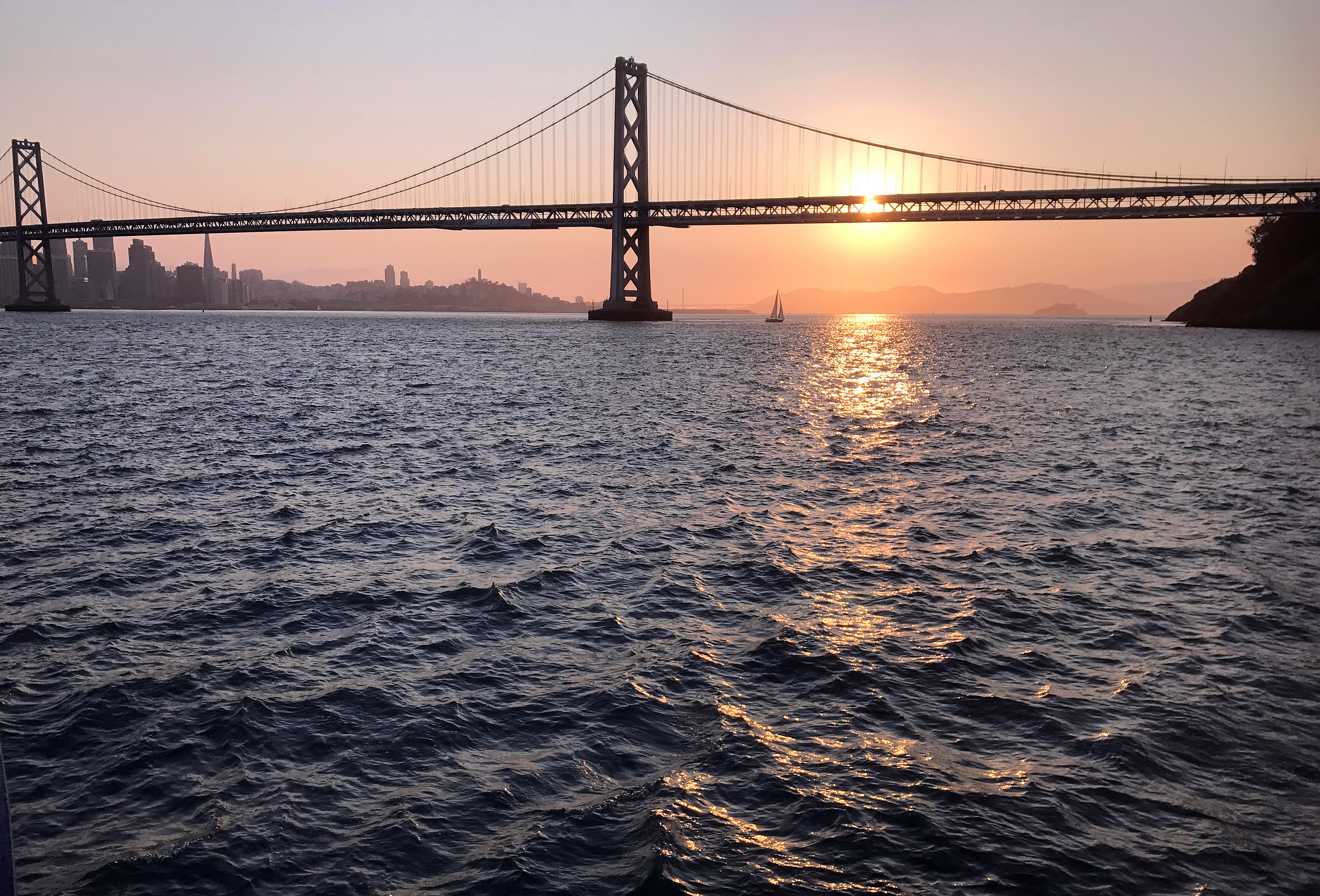 View of San Francisco Bay Bridge at sunset, with San Francisco in the background, in California