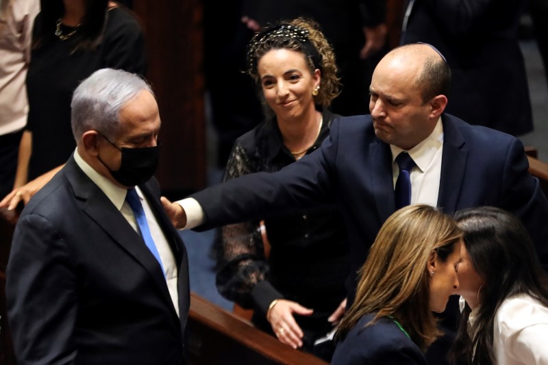 Head of Oposition Benjamin Netanyahu and Israel Prime Minister Naftali Bennett gesture following the vote on the new coalition at the Knesset, Israel's parliament, in Jerusalem