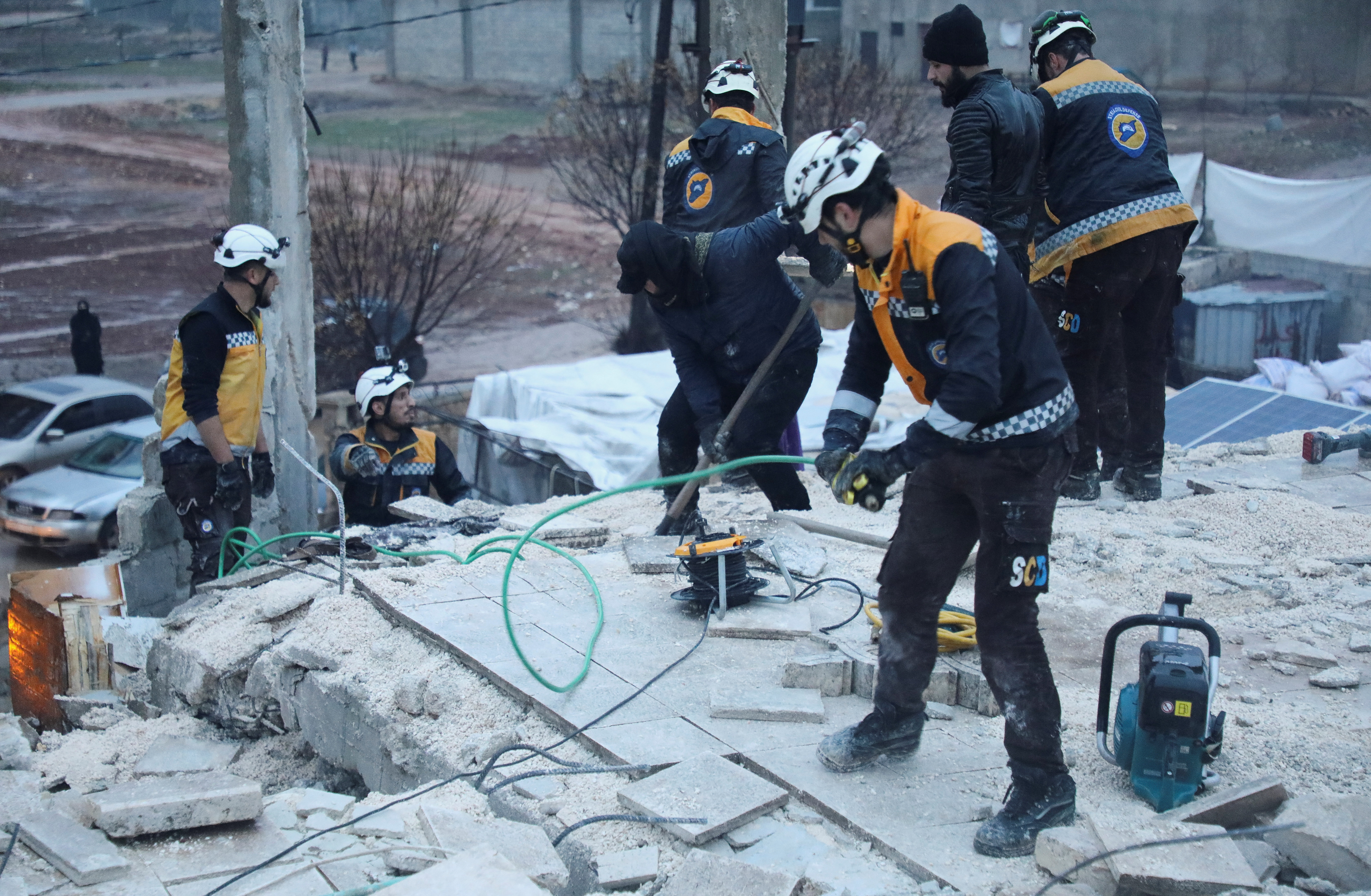 Rescuers work at the site of a damaged building, following an earthquake, in rebel-held Azaz
