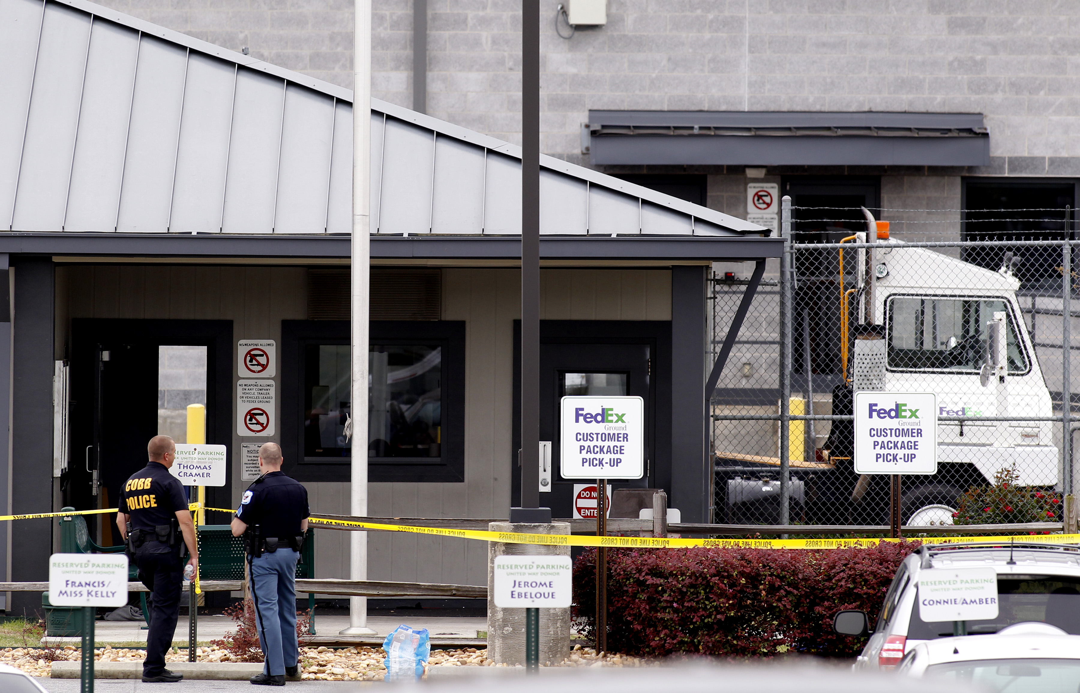 Cobb County police investigate the scene at the guard shack after a shooting at a FedEX Corp facility at an airport in Kennesaw