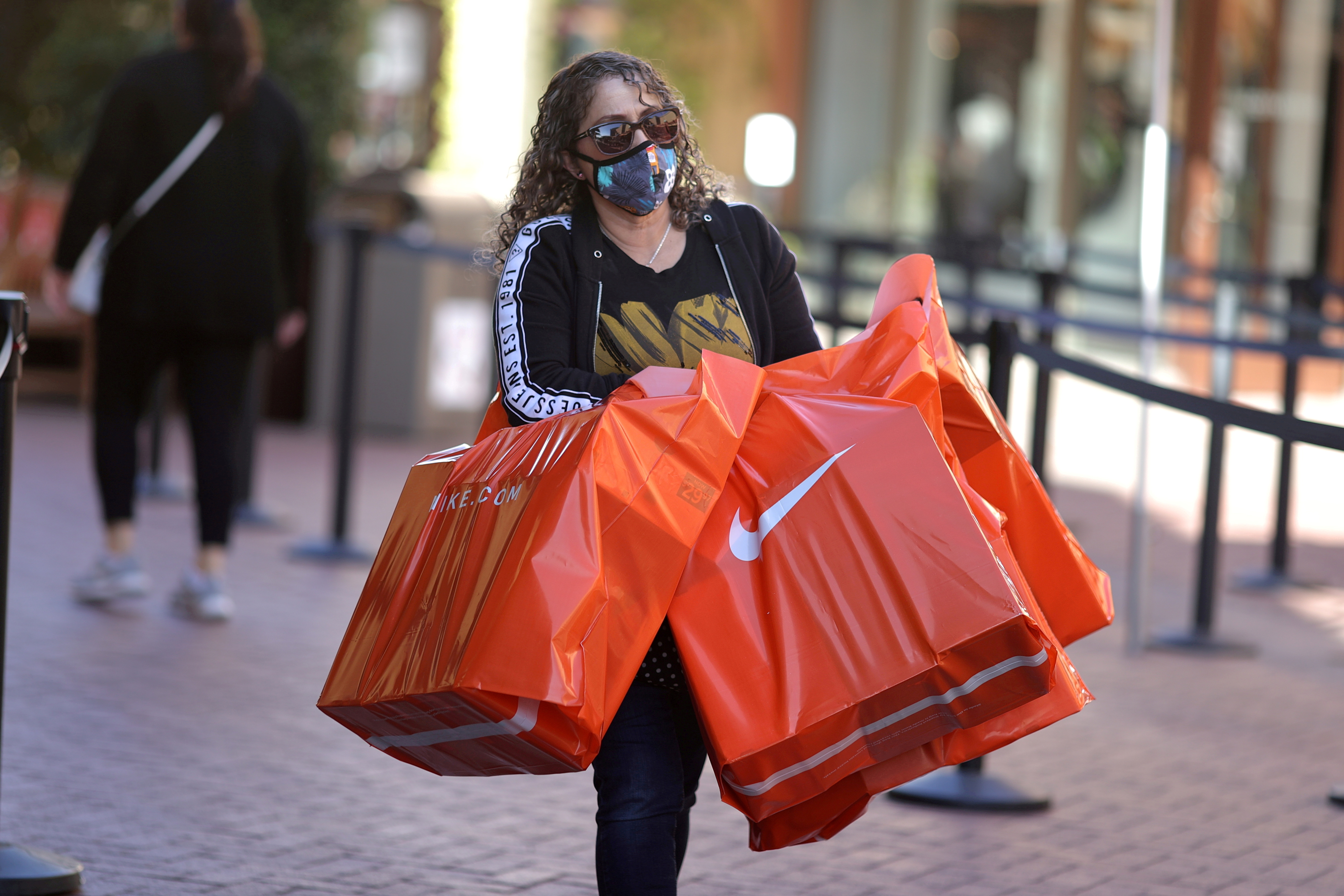 A woman carries Nike shopping bags at the Citadel Outlet mall, as the global outbreak of the coronavirus disease (COVID-19) continues, in Commerce, California, U.S., December 3, 2020. REUTERS/Lucy Nicholson/File Photo/File Photo/File Photo