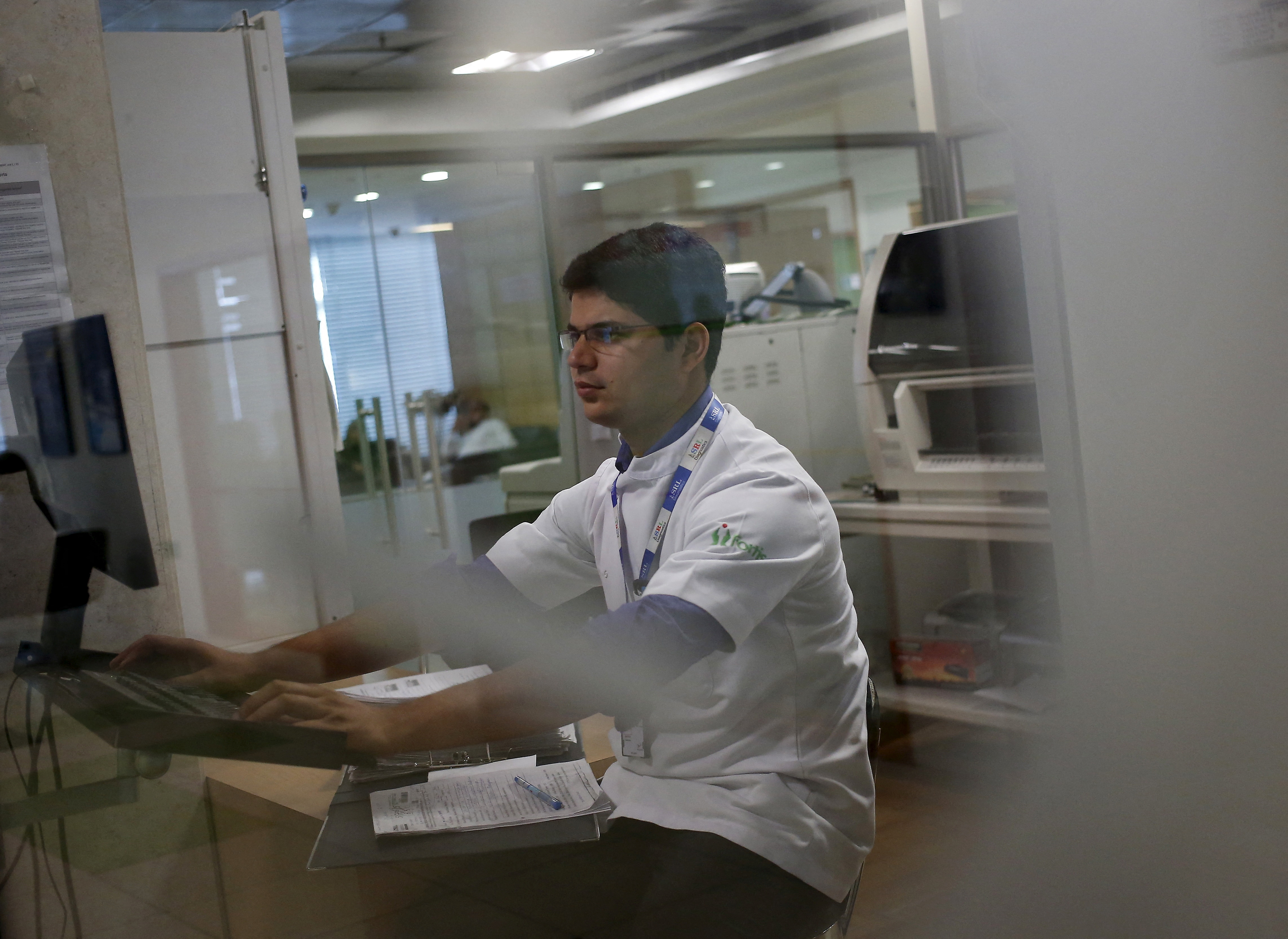 A lab technician works at the Fortis Memorial Hospital at Gurgaon