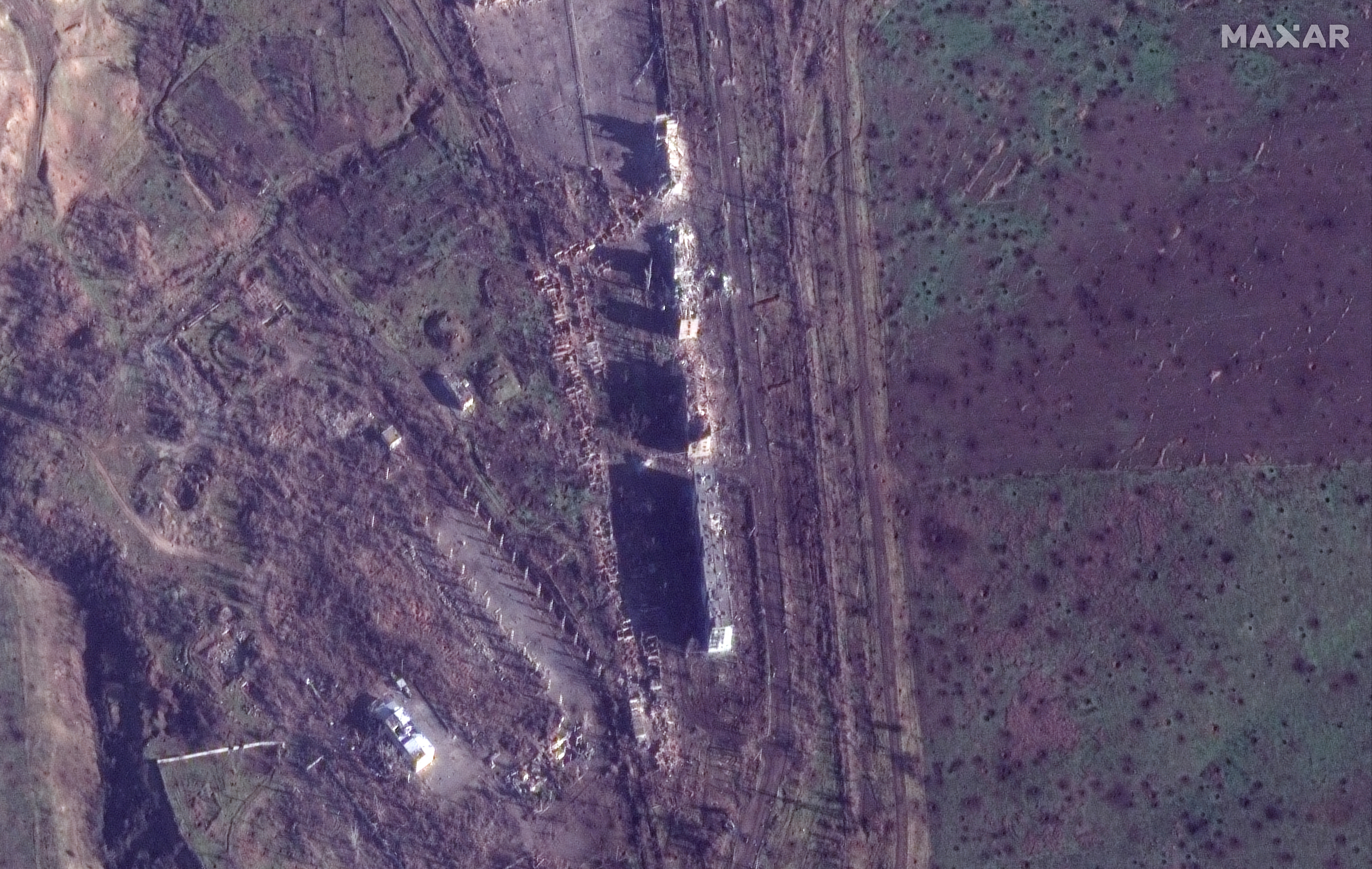 Satellite view of damaged apartment buildings and cratered fields from fighting east of Bakhmut