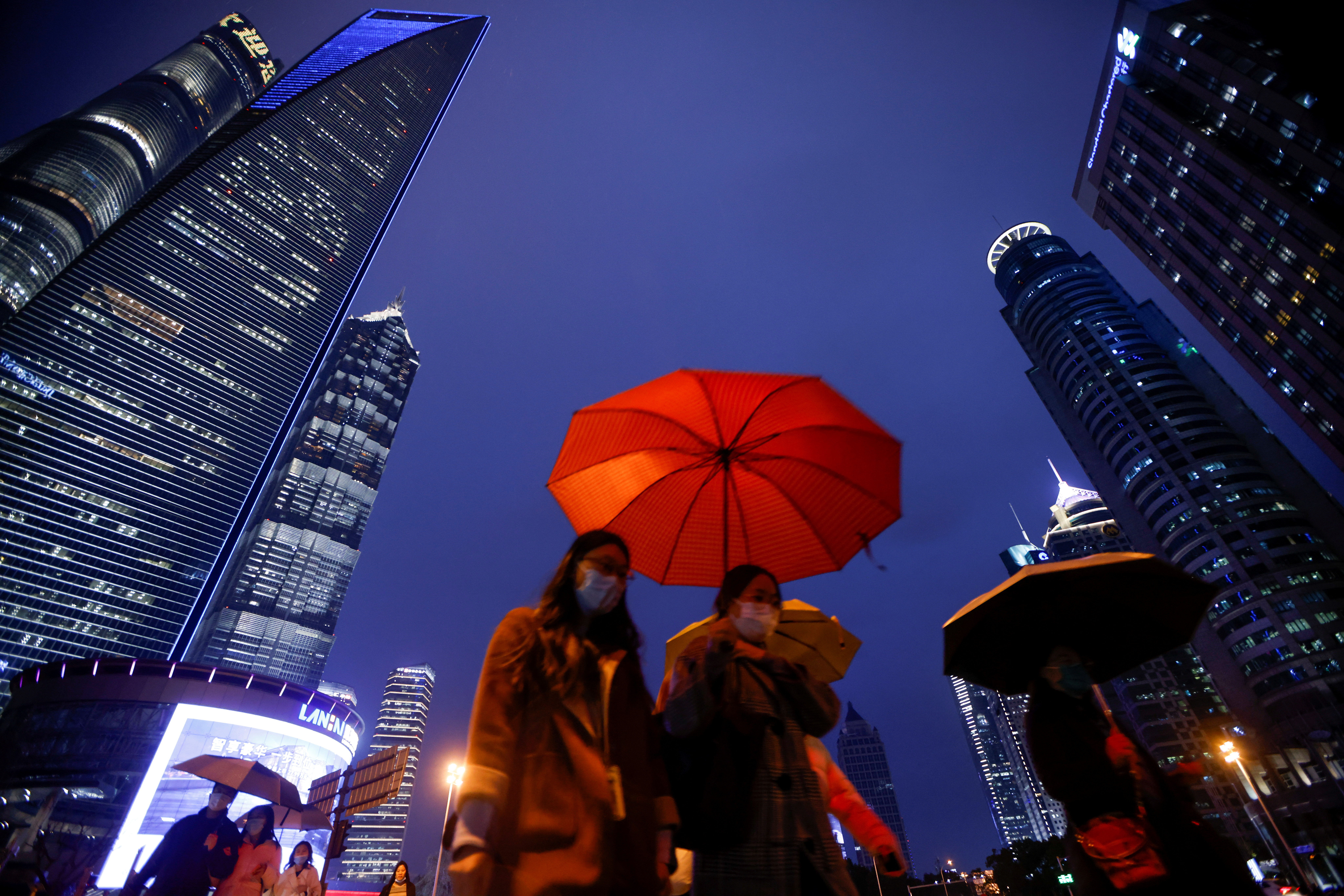 People walk with umbrellas in Lujiazui financial district in Pudong, Shanghai