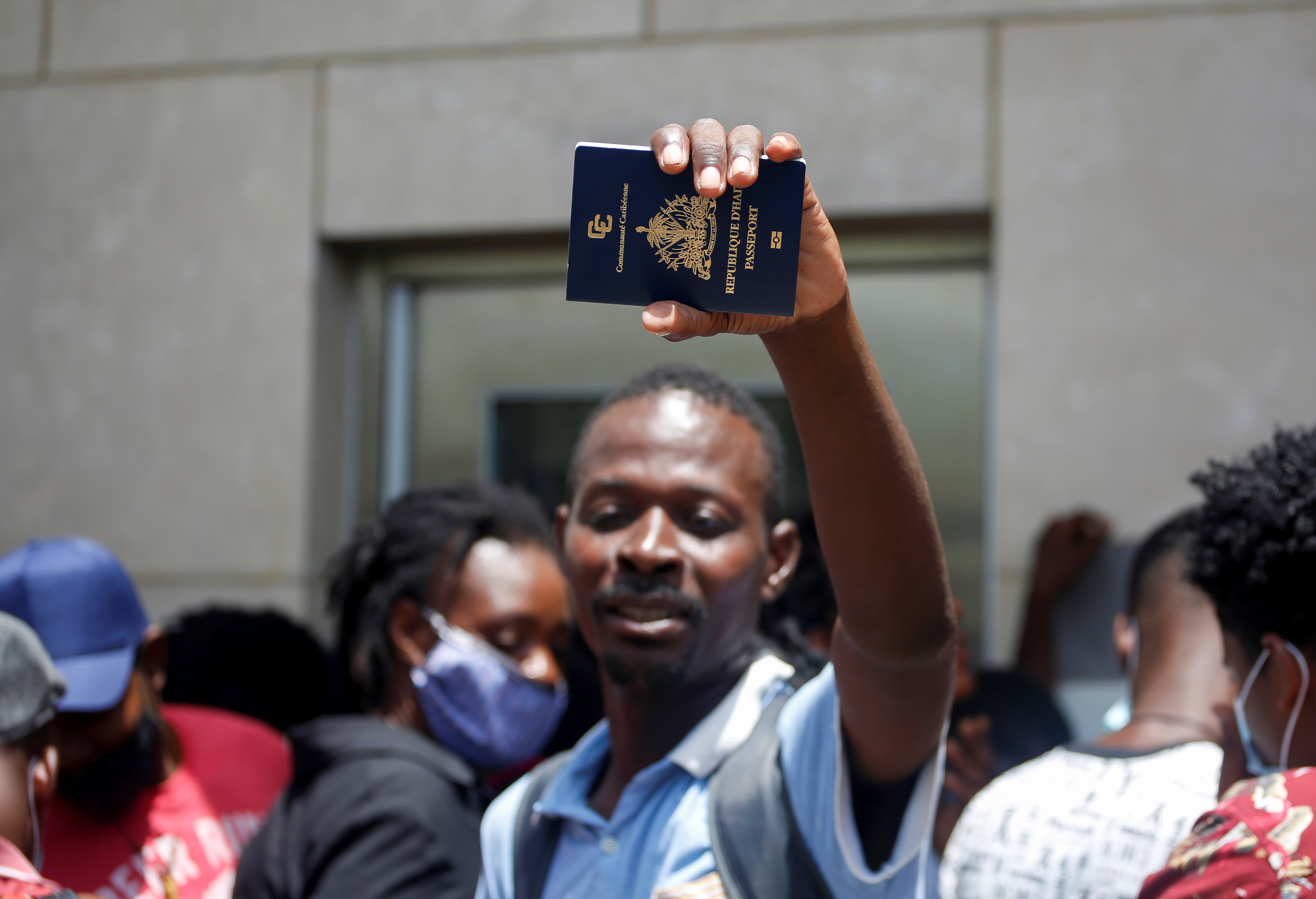 Un hombre haitiano muestra su pasaporte frente a la embajada de los Estados Unidos después del asesinato del presidente Jovenel Moise, en Puerto Príncipe, Haití, el 9 de julio de 2021. REUTERS / Estailove St-Val 