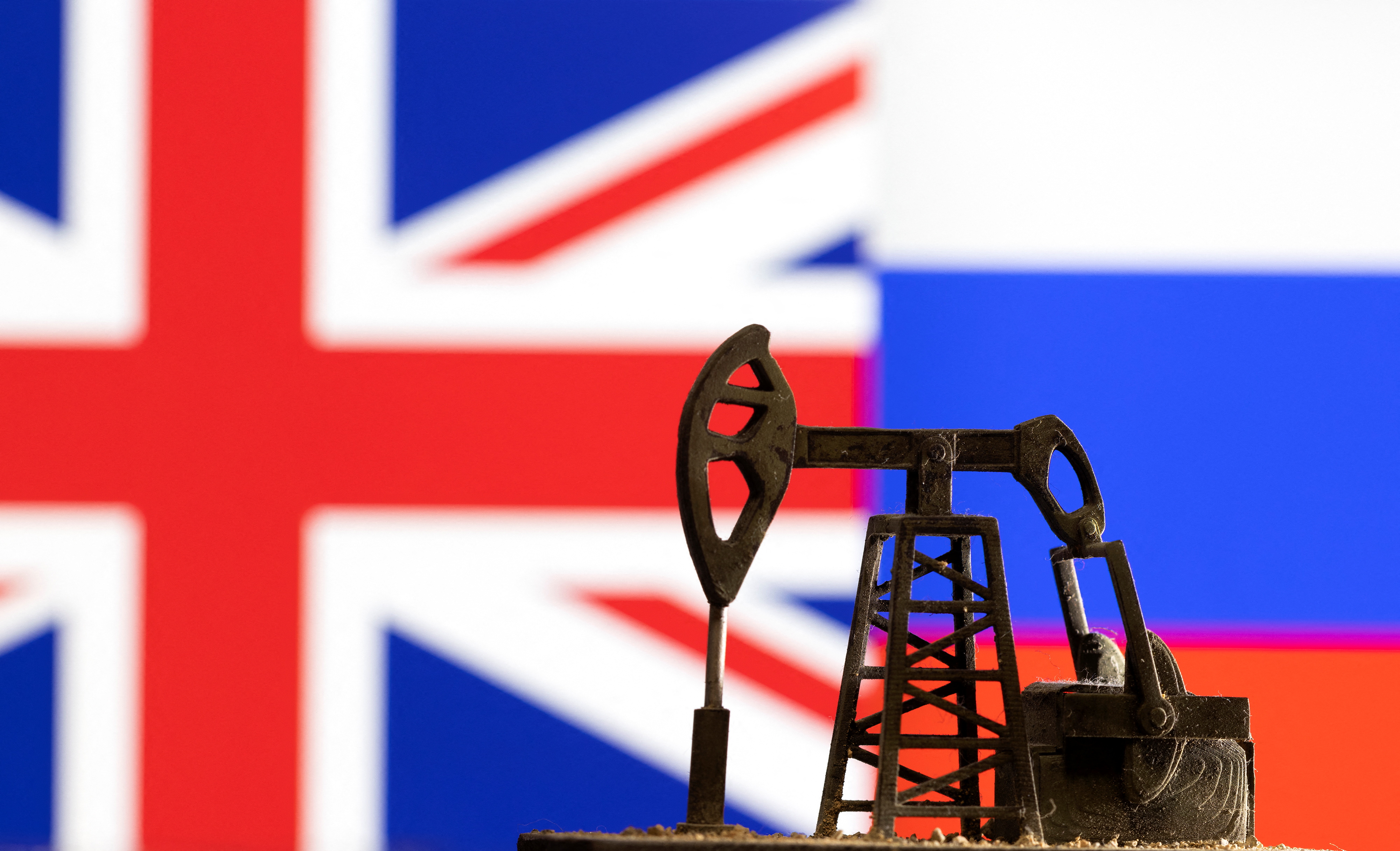 Illustration shows pump jack in front UK and Russia flag colours