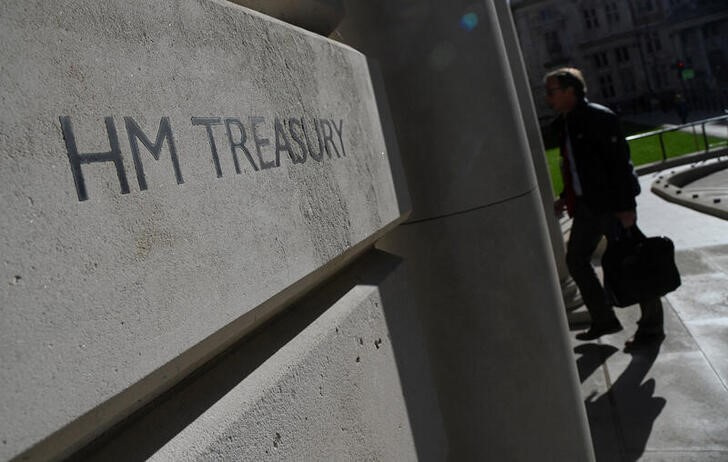 A worker walks into the Treasury building in London
