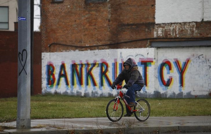 A man rides his bike past graffiti in Detroit