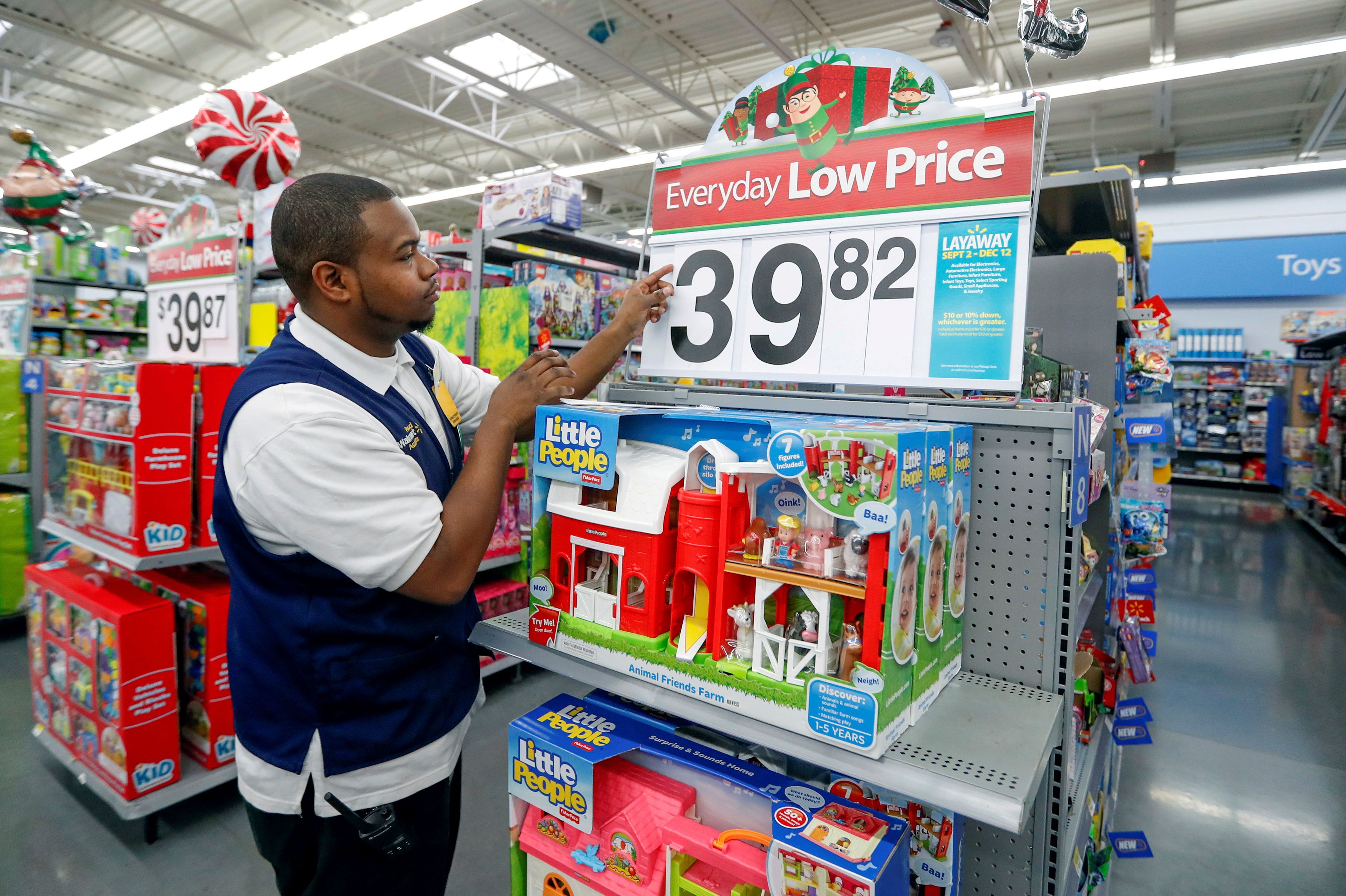An employee puts up a price tag ahead of Black Friday at a Walmart store in Chicago
