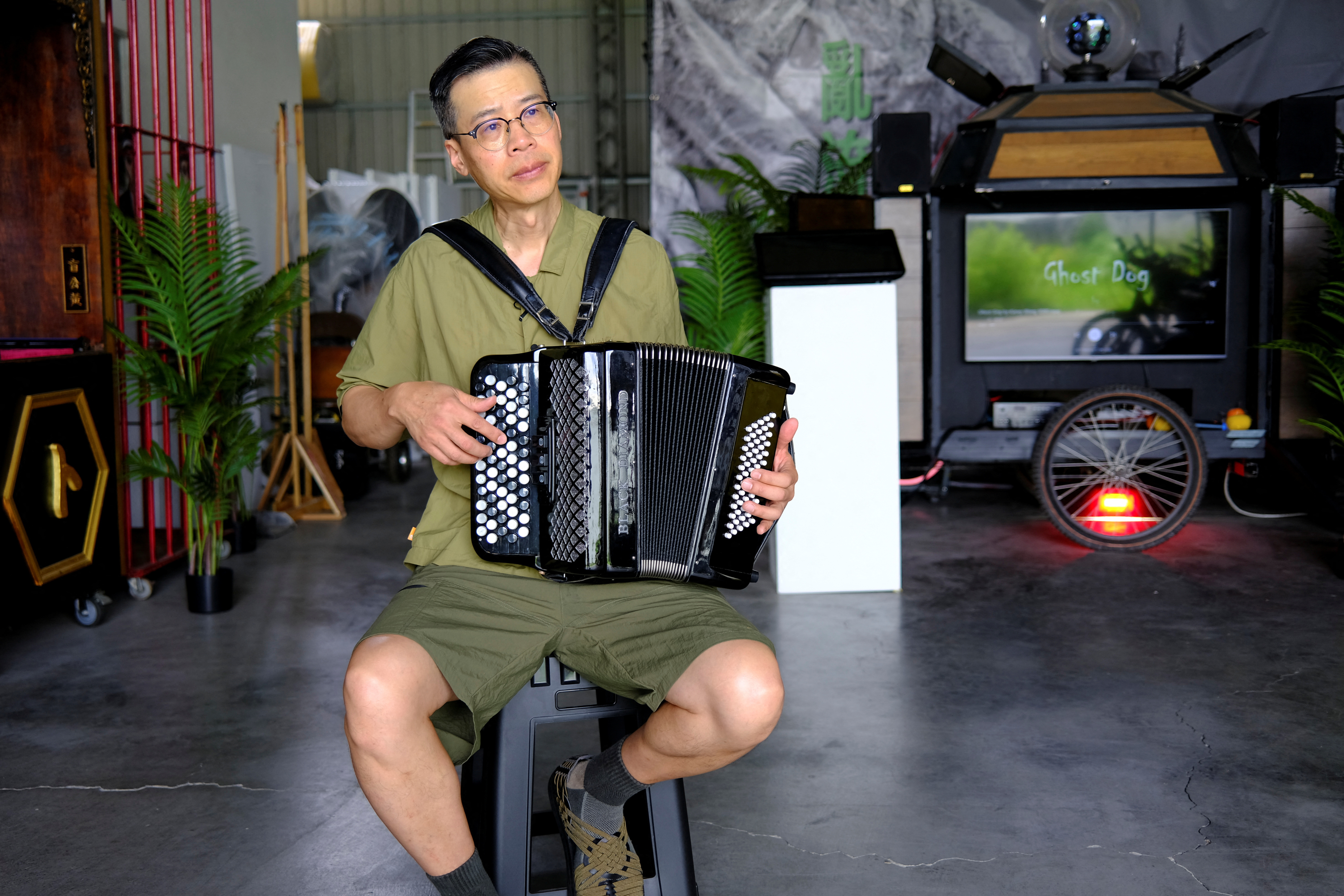 Artist Kacey Wong plays the accordion for the camera during an interview with Reuters at his studio in Taichung