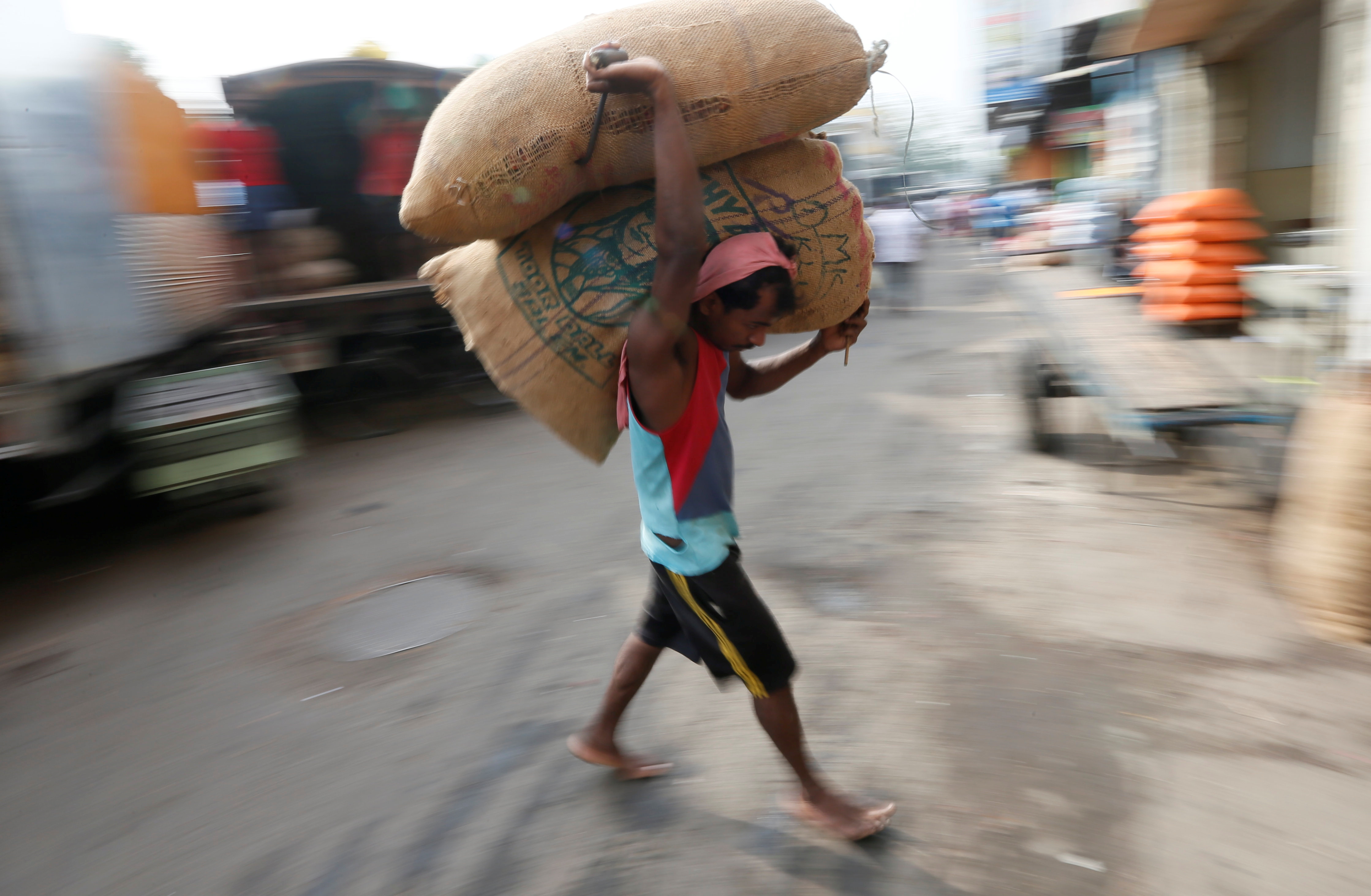 A worker carries a sack of rice at main market in Colombo
