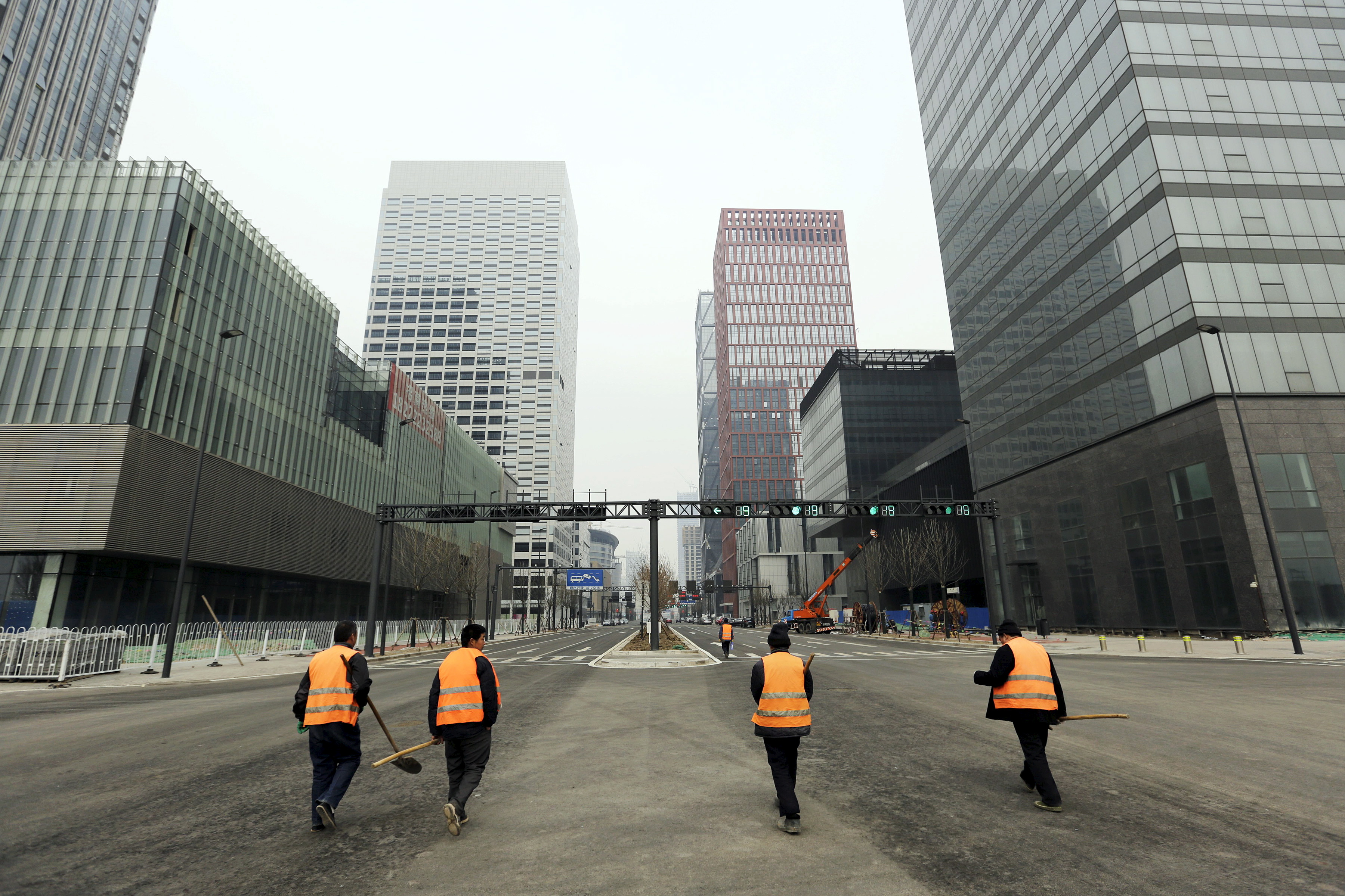 Workers walk through the Yujiapu financial centre, in Tianjin