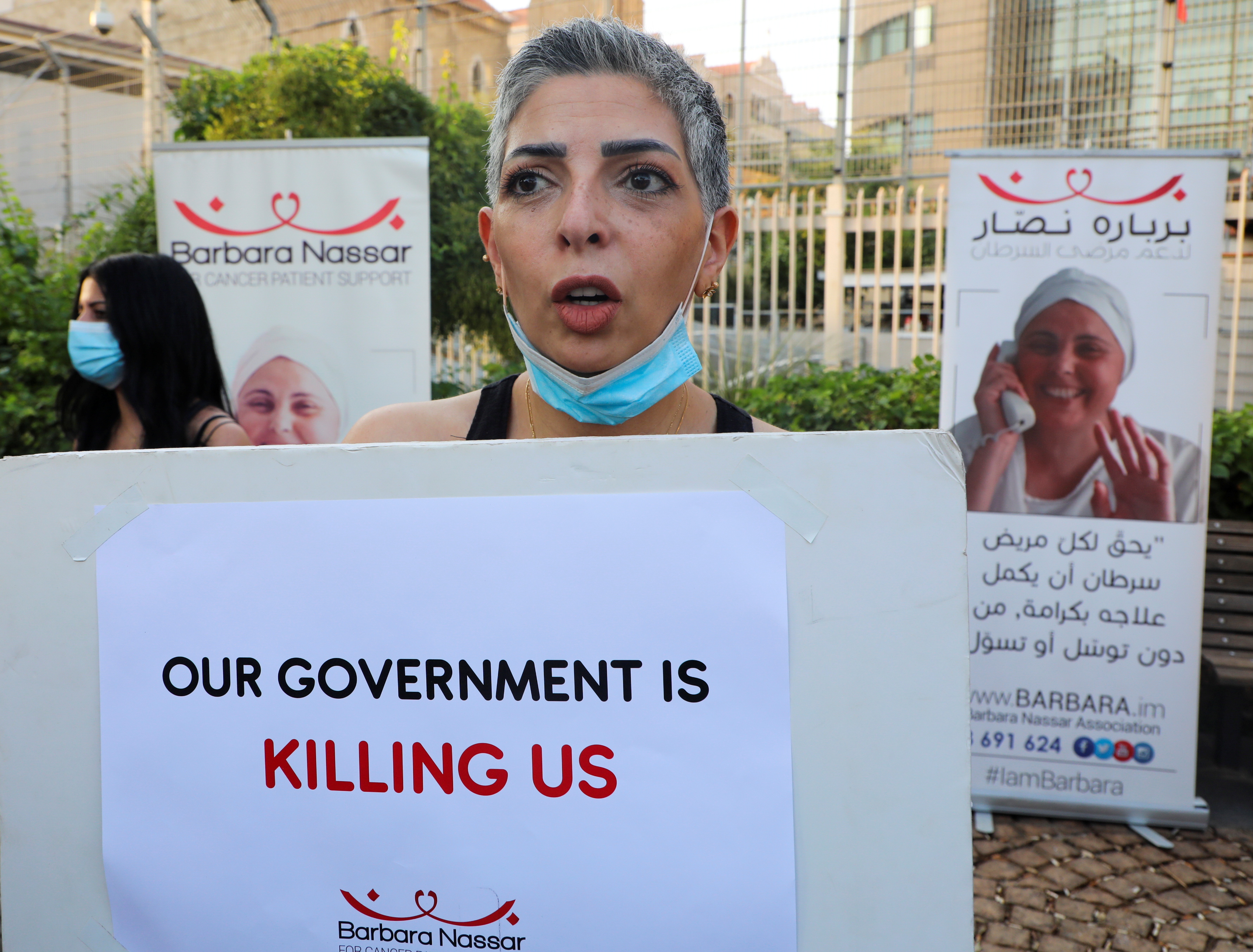 A cancer patient holds a sign, during a sit-in demonstration as shortages of cancer medications spread, in front of the U.N. headquarters in Beirut