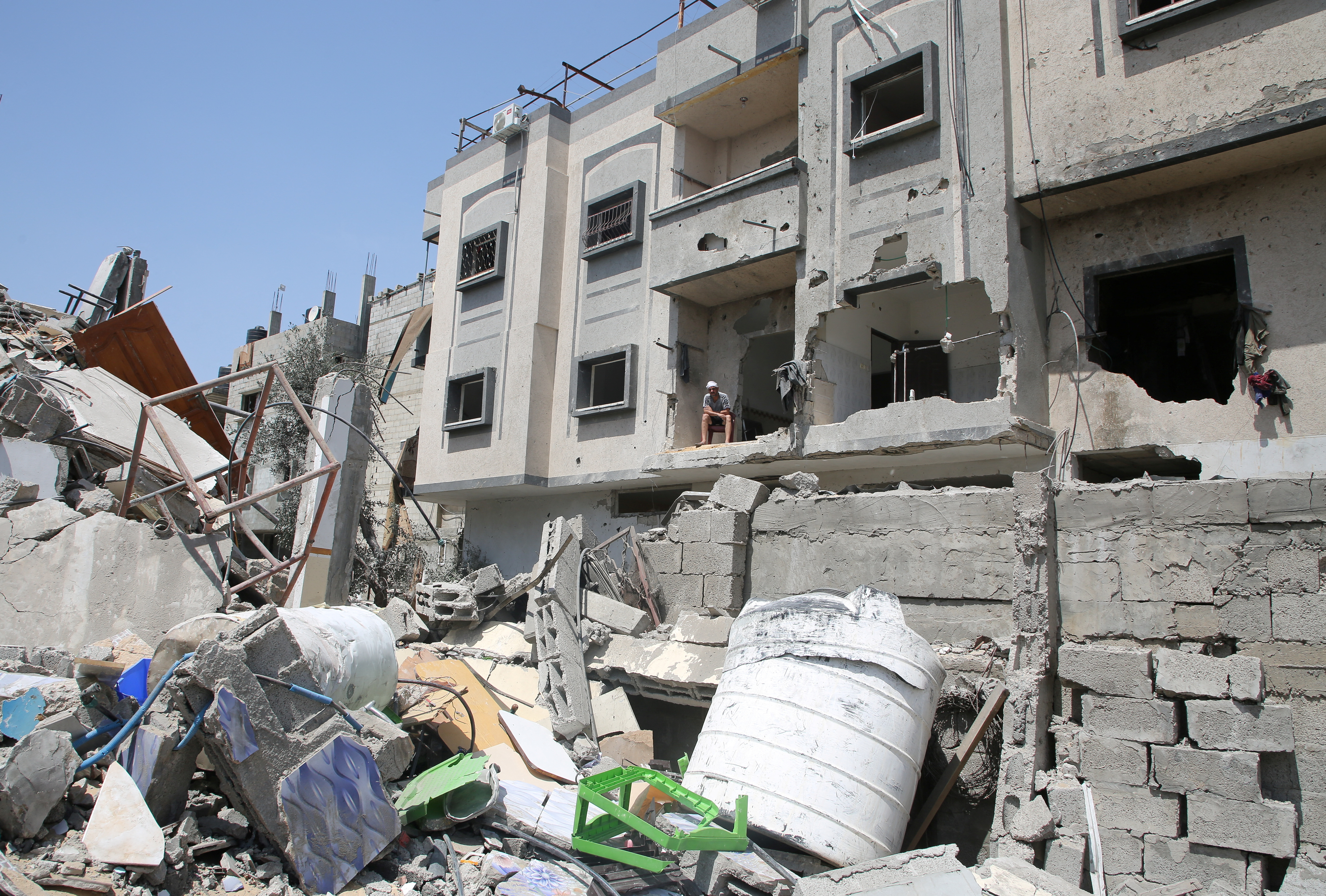 Palestinian Abdel Rahman Barika looks at the site of an Israeli strike, in Rafah